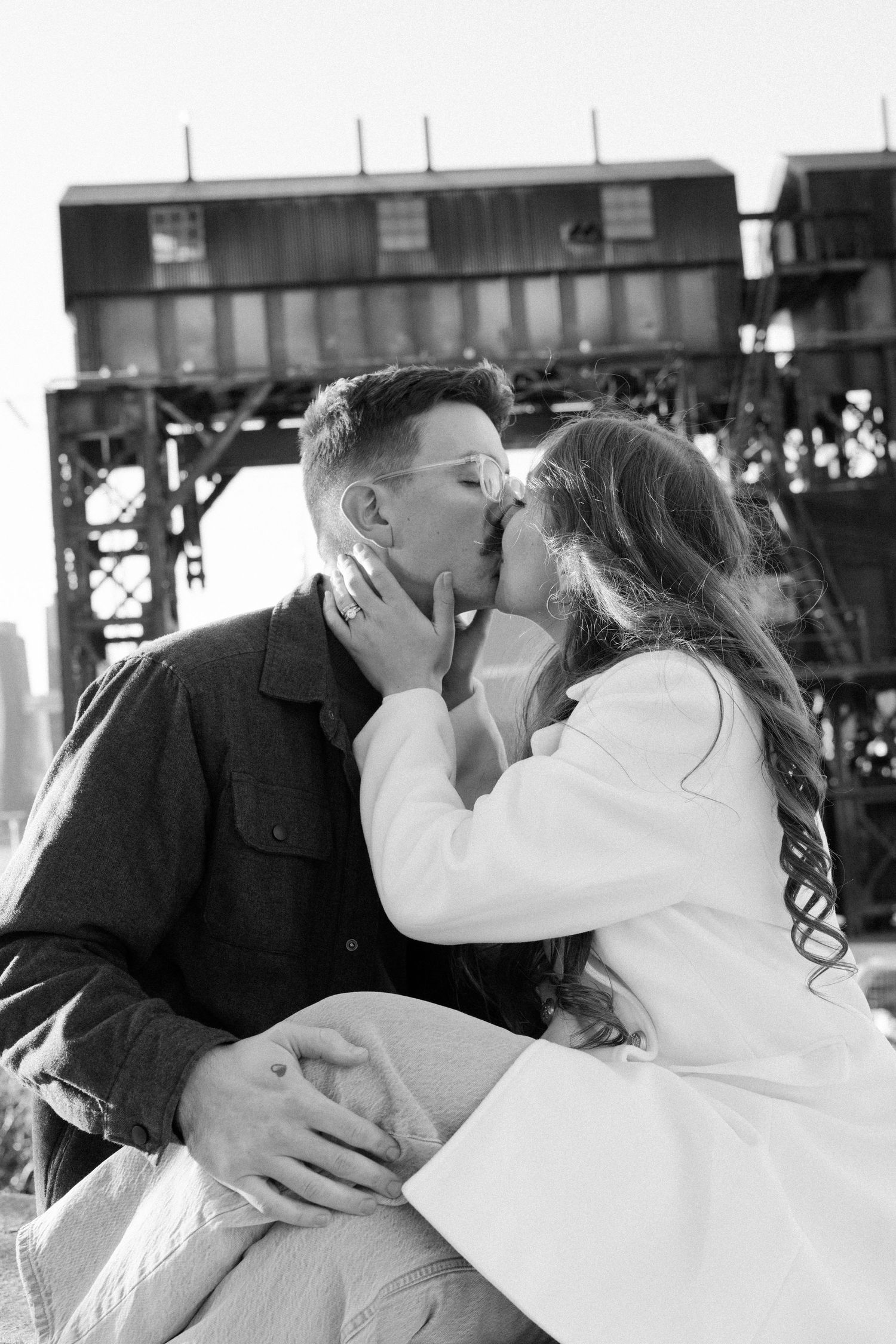 A romantic black and white photo series showing a couple sharing intimate kisses at an event.