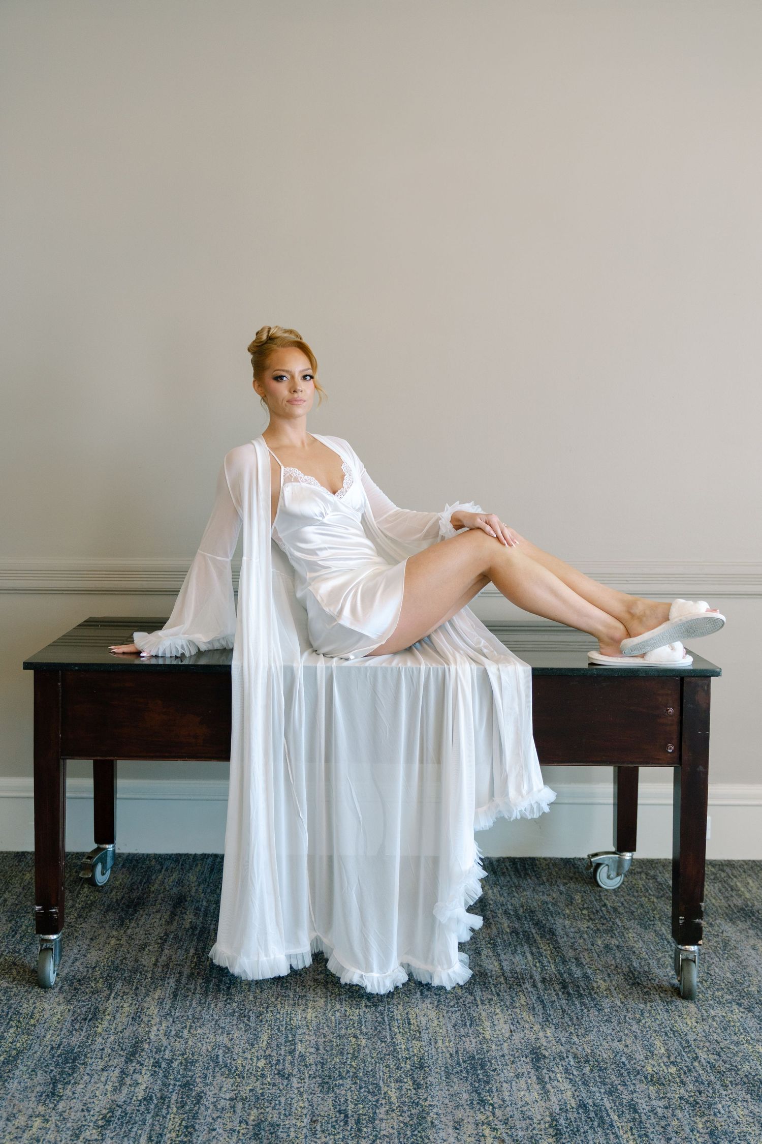 Artistic bridal boudoir photo series on wooden benches with flowing white fabric.