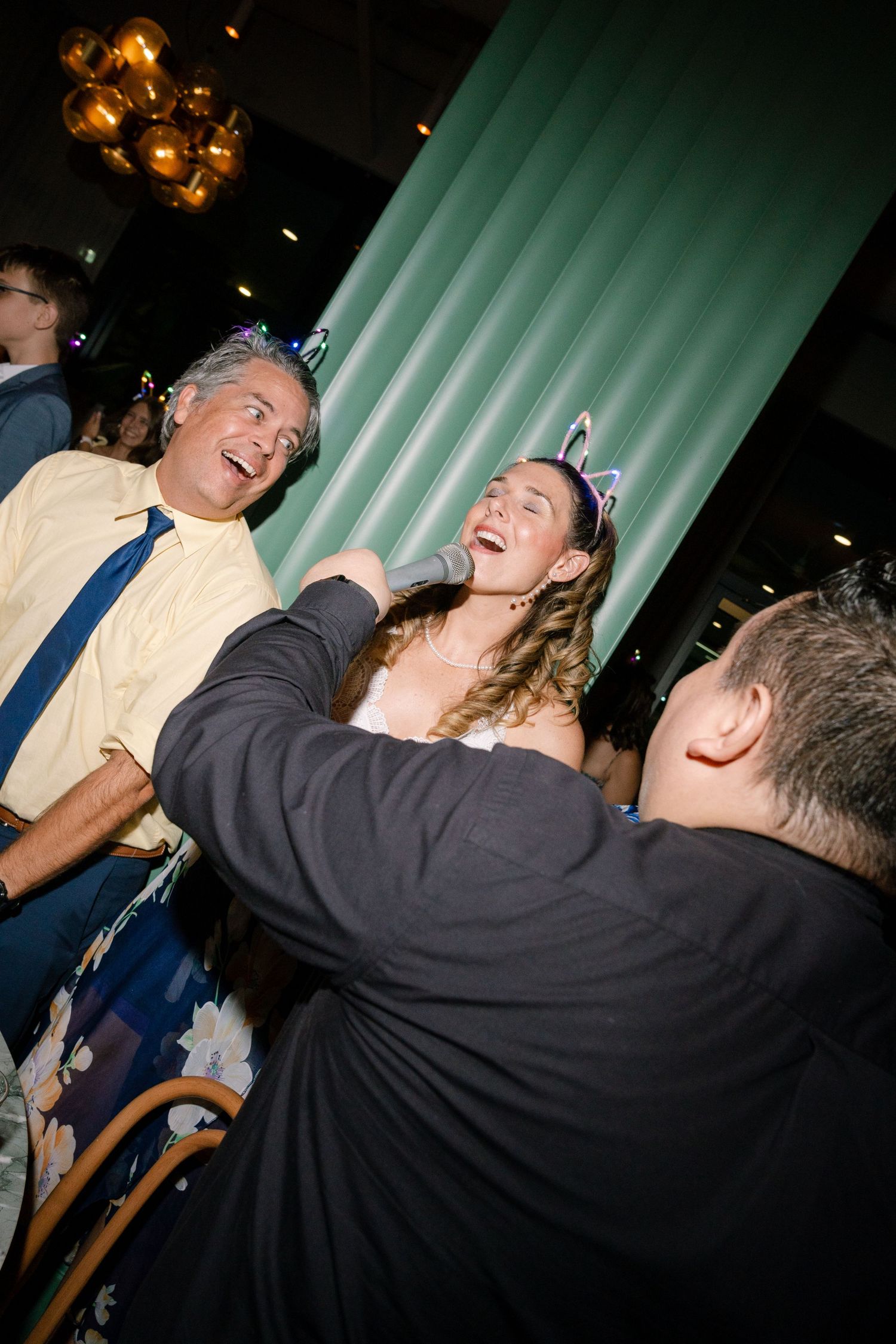 Energetic dancing and celebration captured at a nighttime wedding reception.