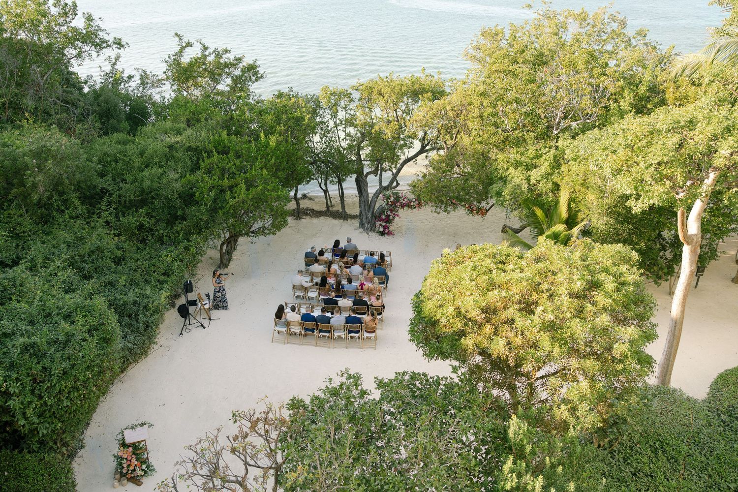Aerial view of wedding guests seated in rows at an outdoor garden venue.