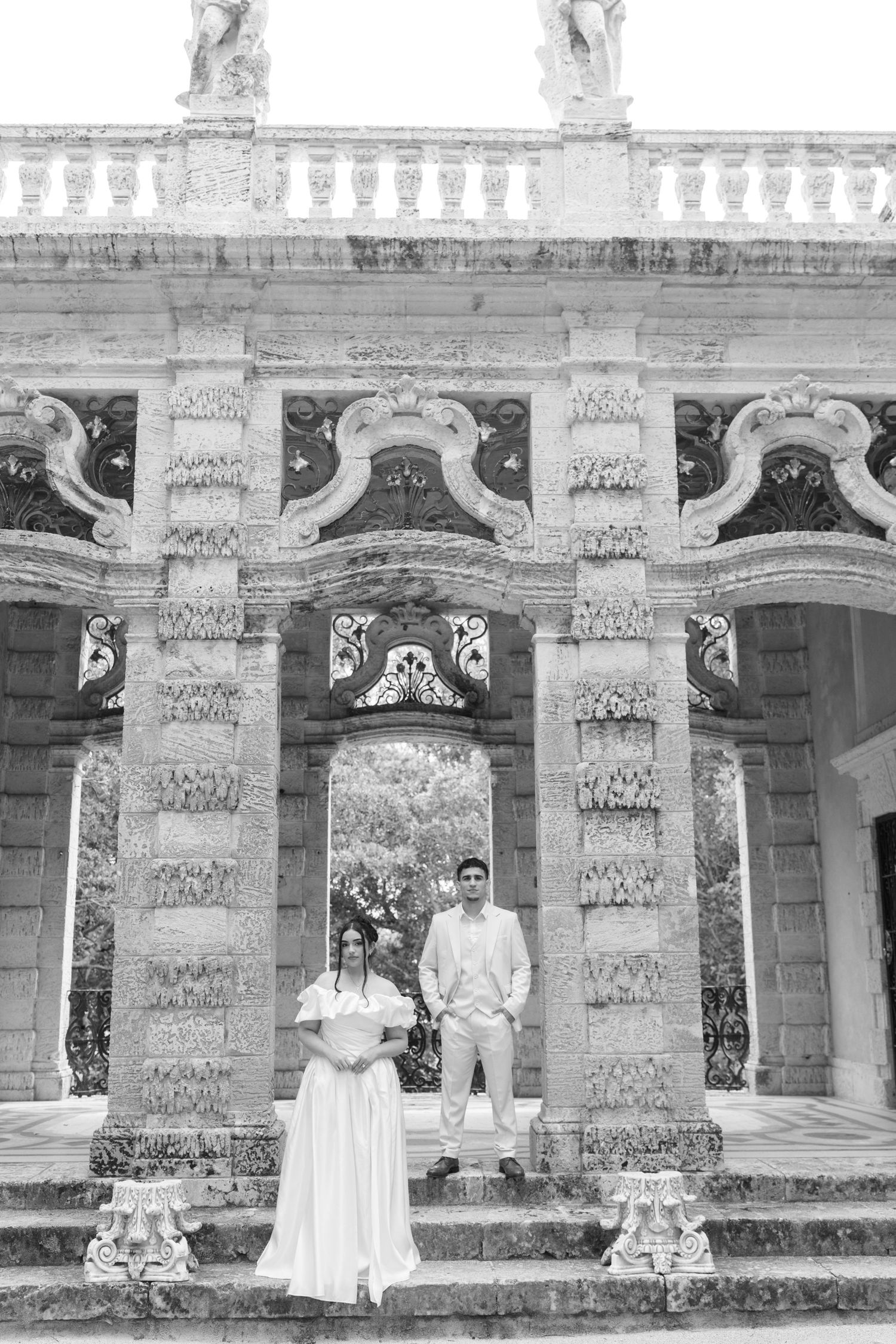Architectural details of an ornate historic colonnade with decorative stonework pillars and arches shown in black and white.