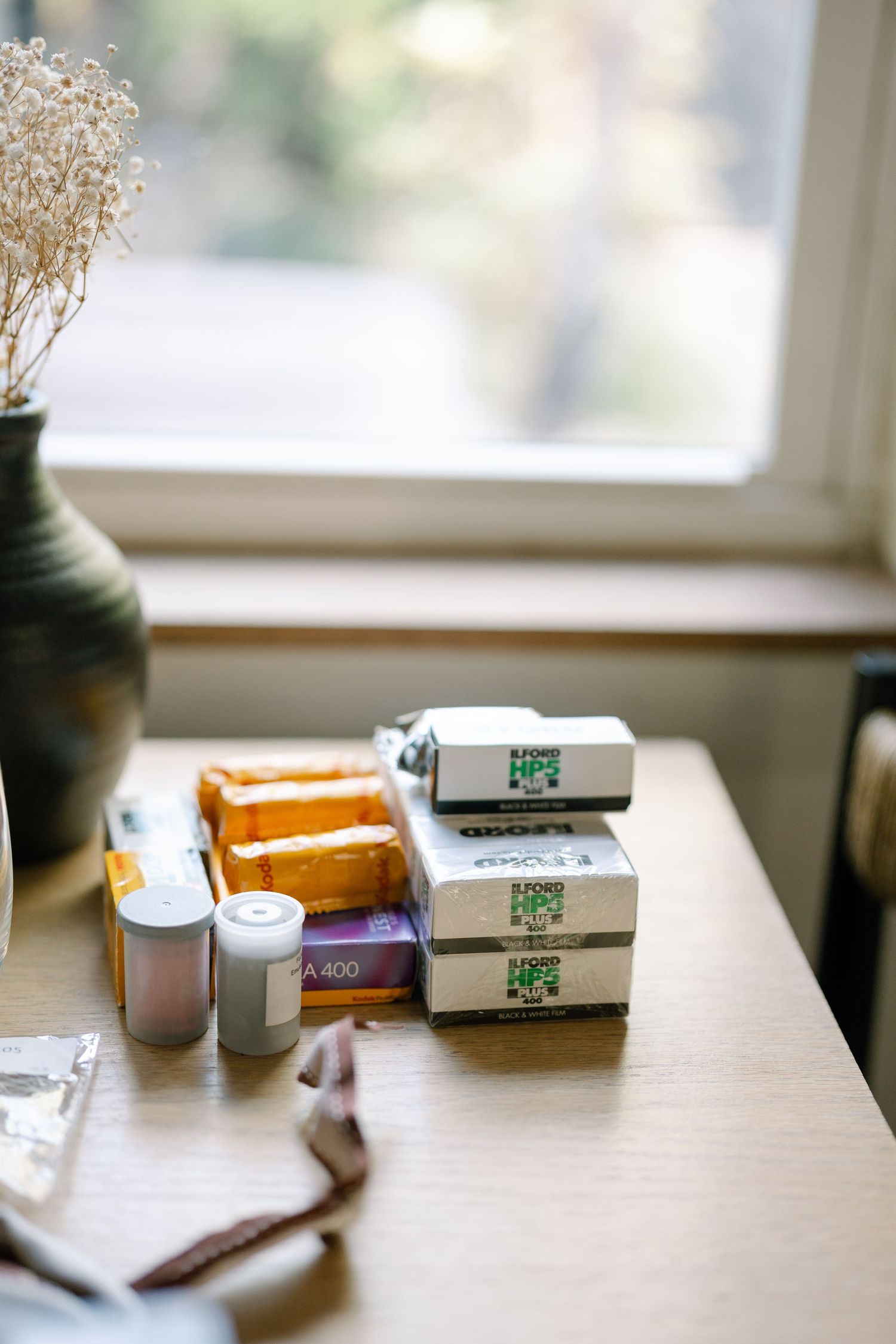 Various medicine boxes and packages arranged on a wooden table near a window.