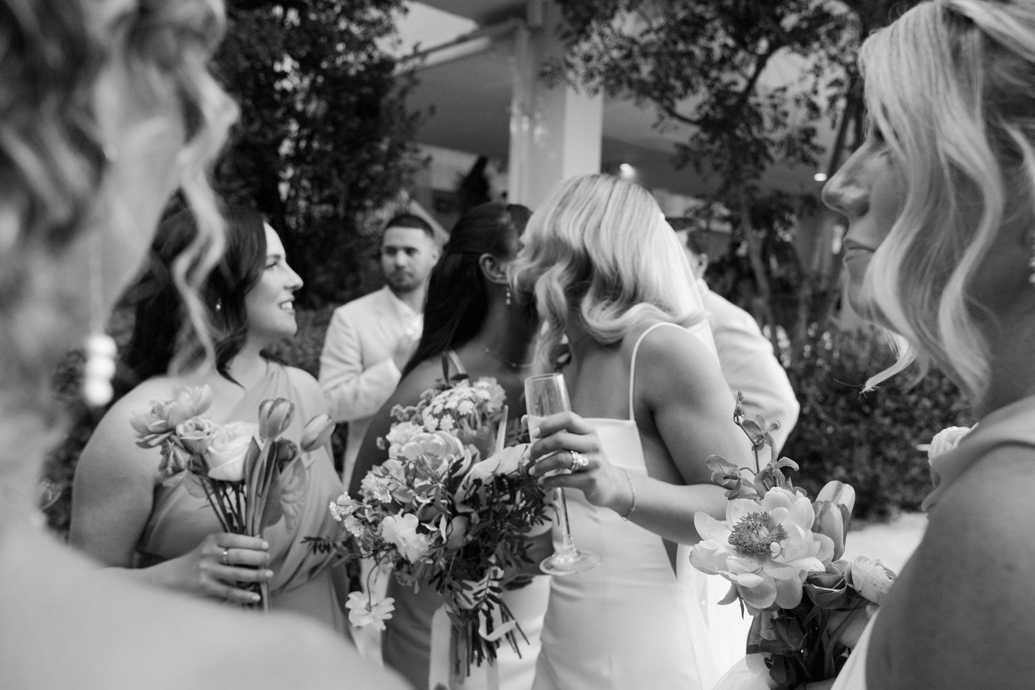 Black and white photo series showing joyful wedding party moments outdoors.