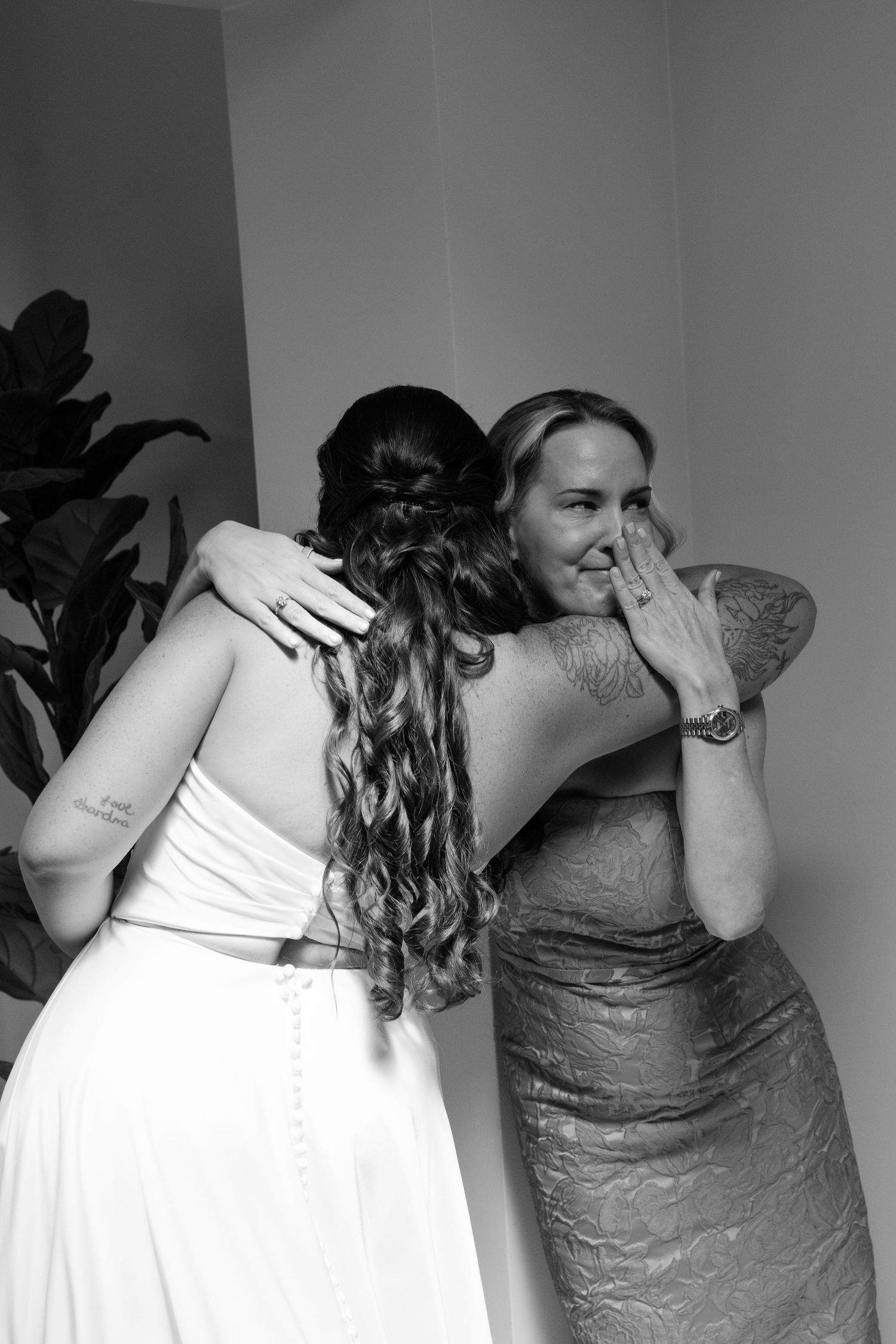Two women embracing and comforting each other in an indoor setting.