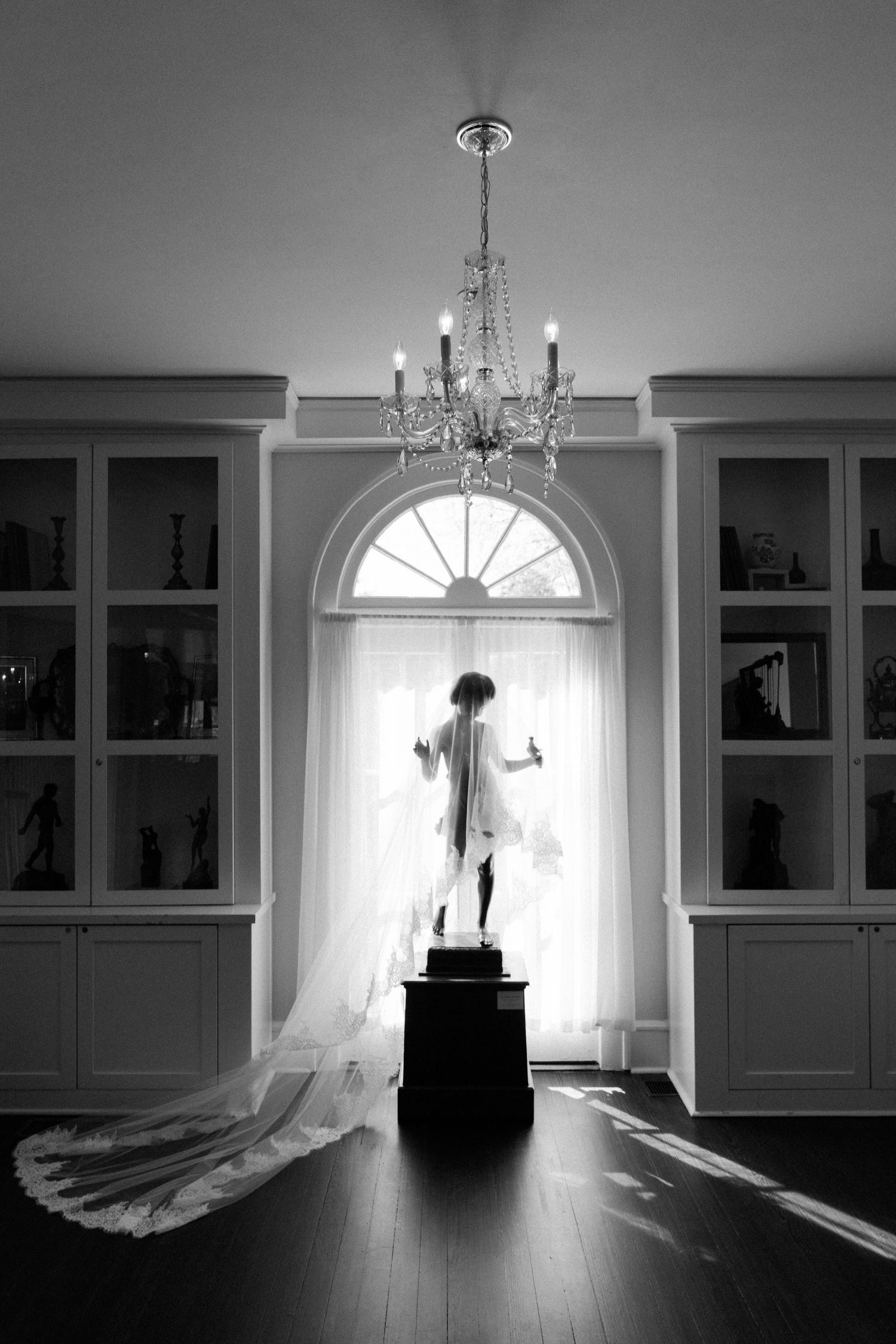 A series of black and white photos showing a dramatic window silhouette with chandelier in an elegant room interior.