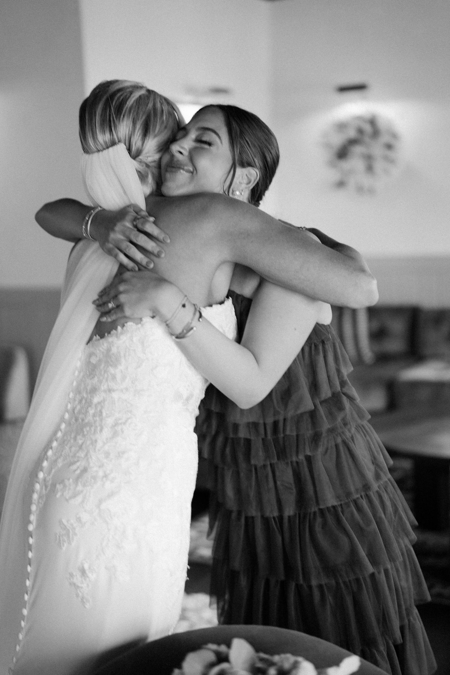 An emotional embrace shared during wedding preparations, captured in black and white.