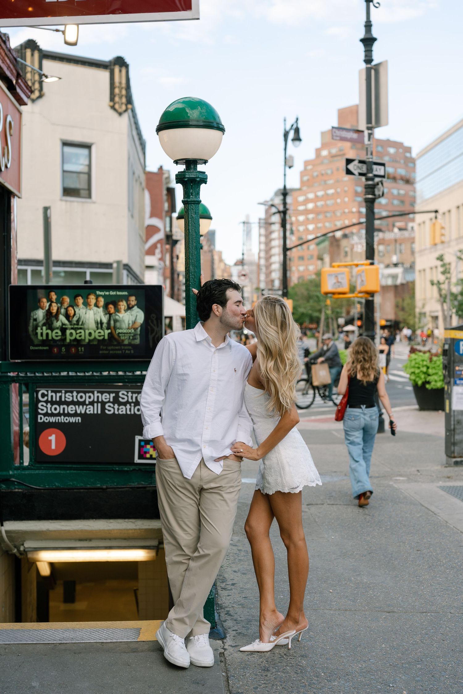 Couple sharing a romantic moment near Christopher Street Stonewall Station subway entrance in NYC.