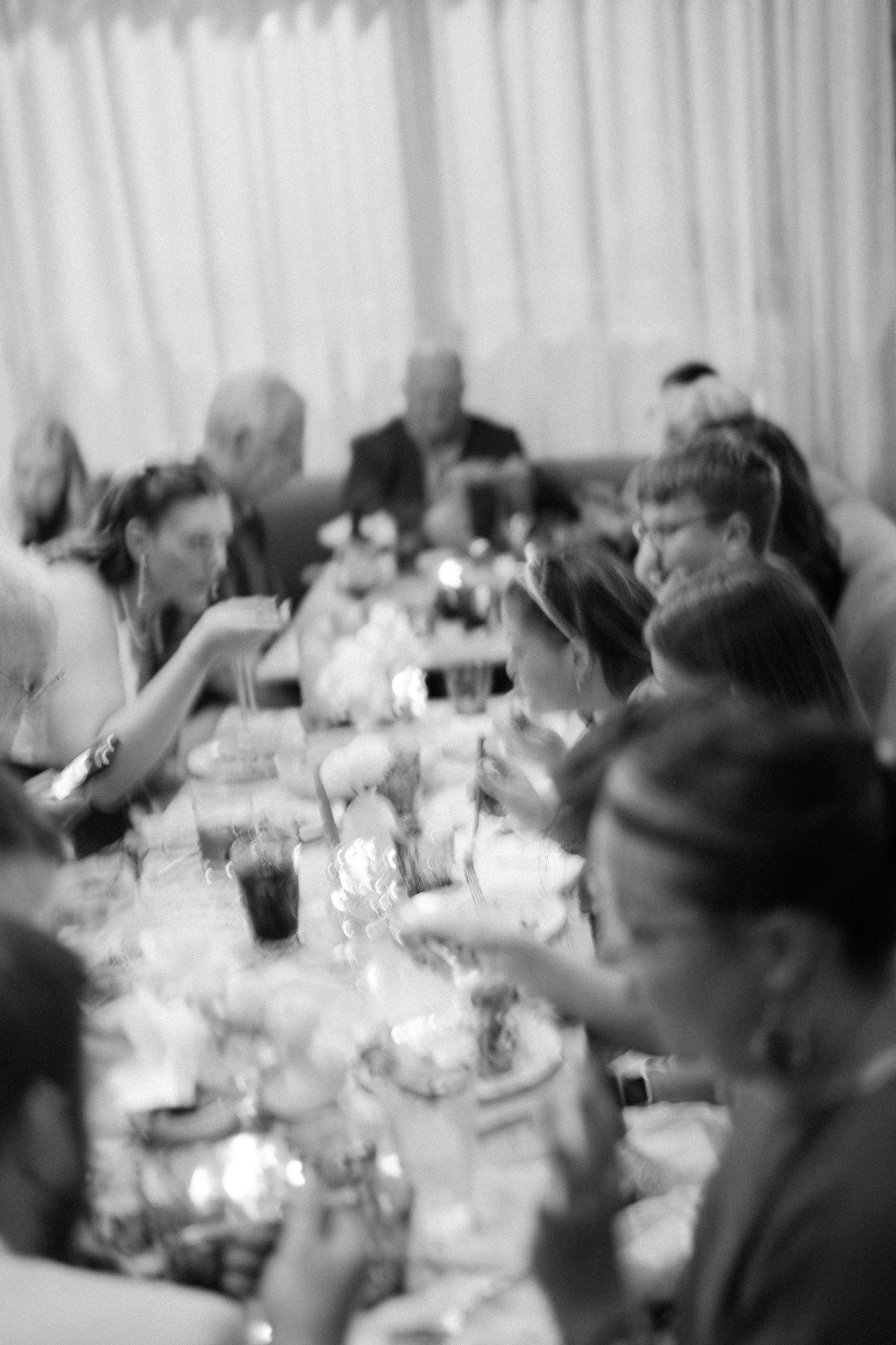 Black and white photograph showing a crowded dining room scene with people seated at tables for a formal gathering.
