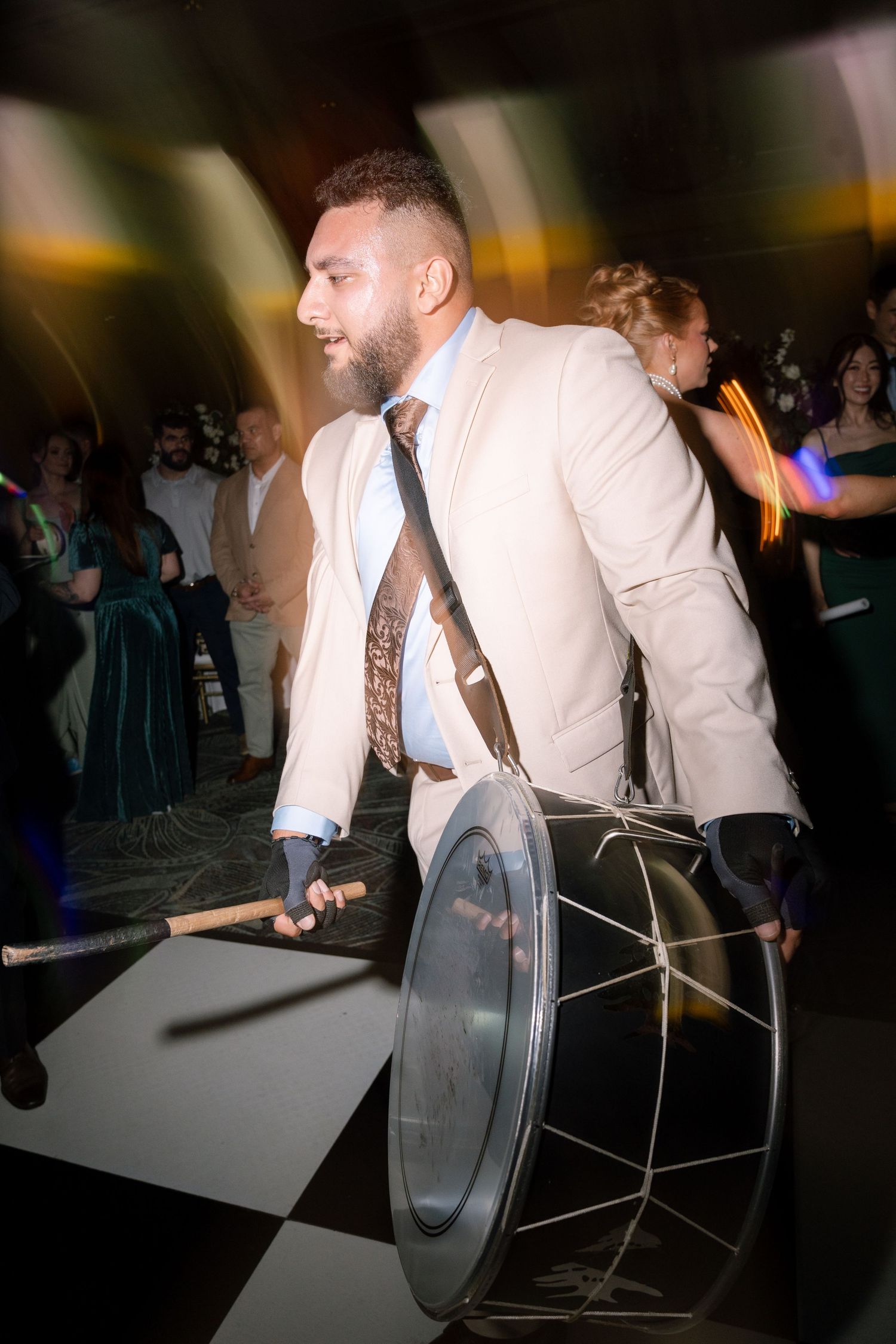 Wedding reception guests playing drums and musical instruments during an energetic celebration.
