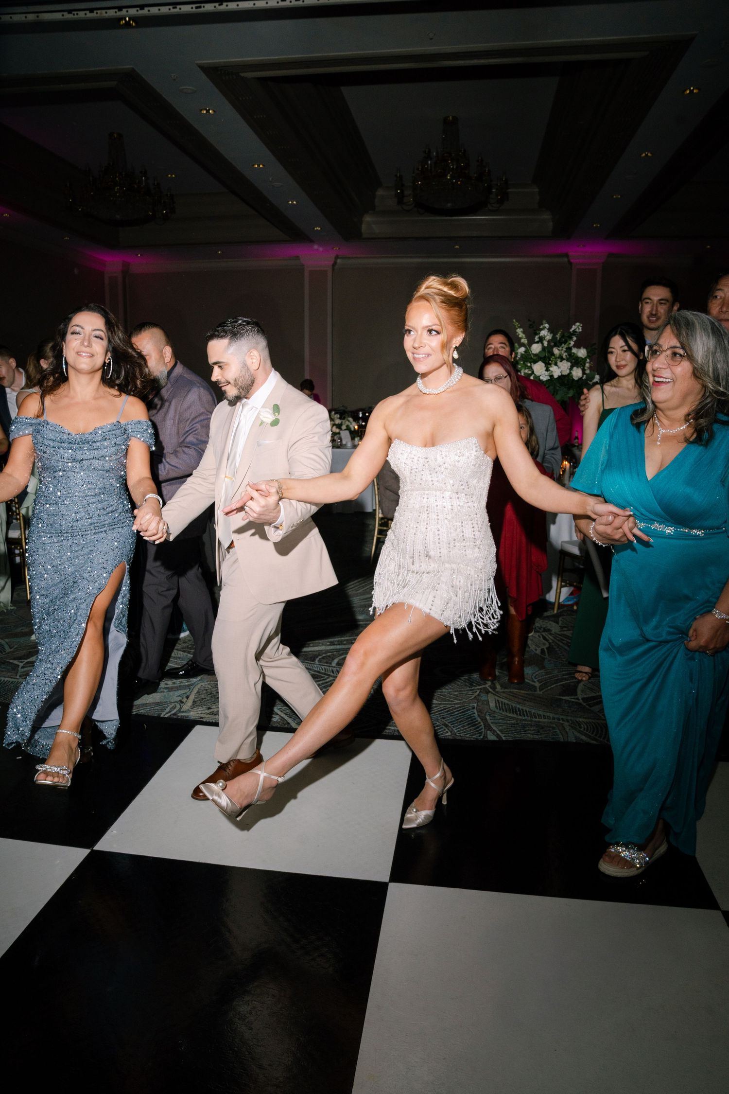 Wedding reception dance floor filled with guests dancing and celebrating.