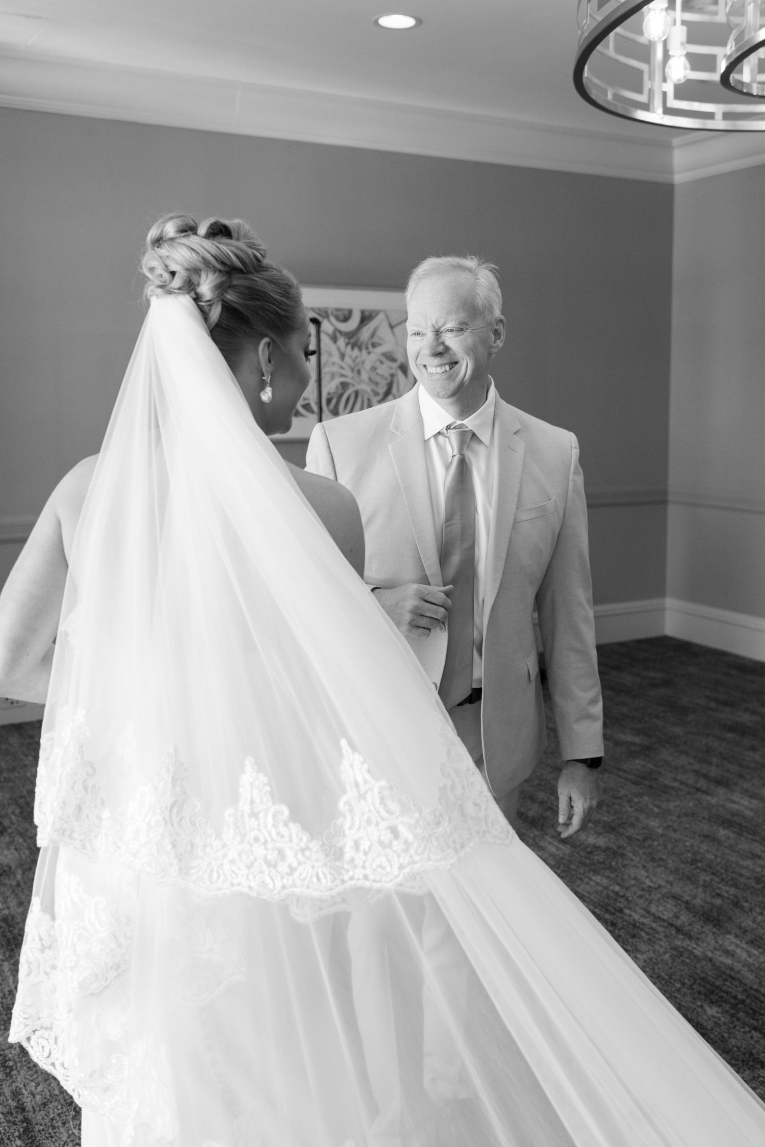Black and white photo capturing an emotional moment during a wedding ceremony.