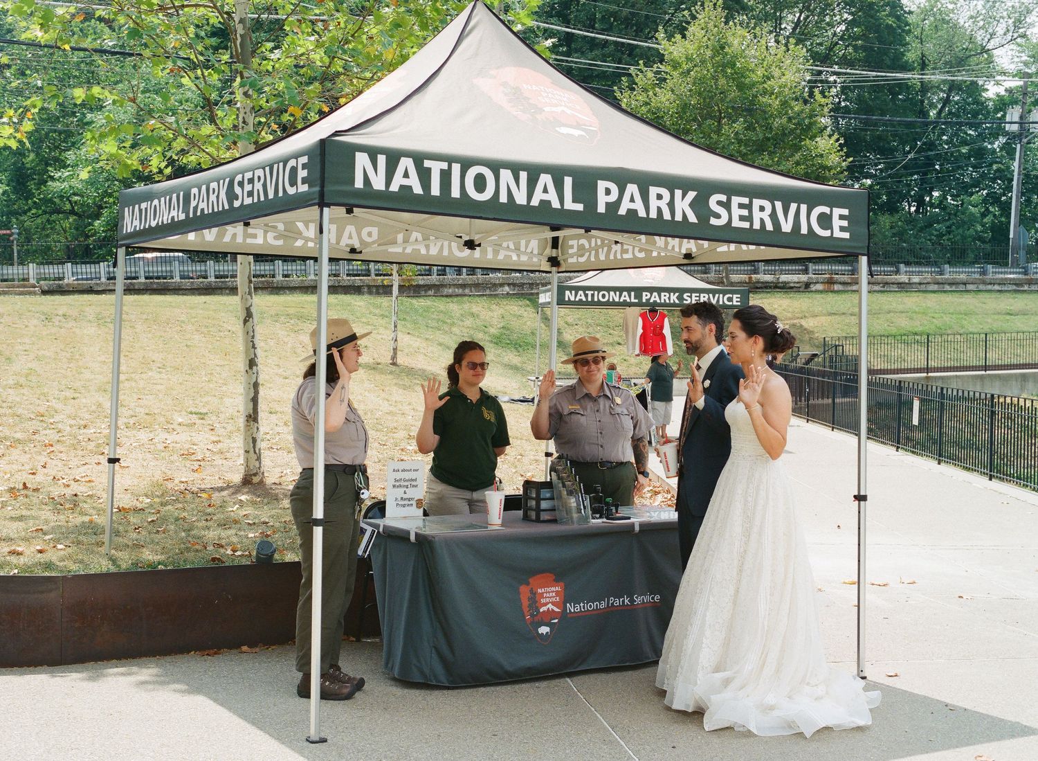 National Park Service booth staff assist visitors at an outdoor tent setup during a community event.