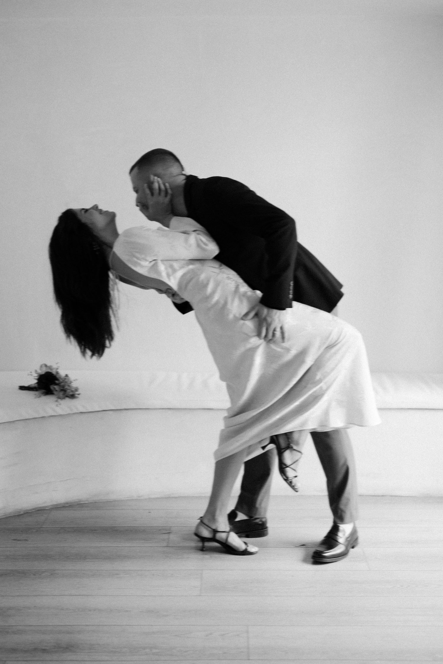 A couple performs a dramatic dance dip pose in black and white, showcasing elegant vintage dance style.