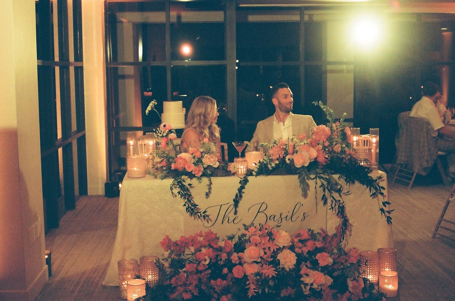 Wedding reception venue with glowing lanterns and tables set for an evening celebration.