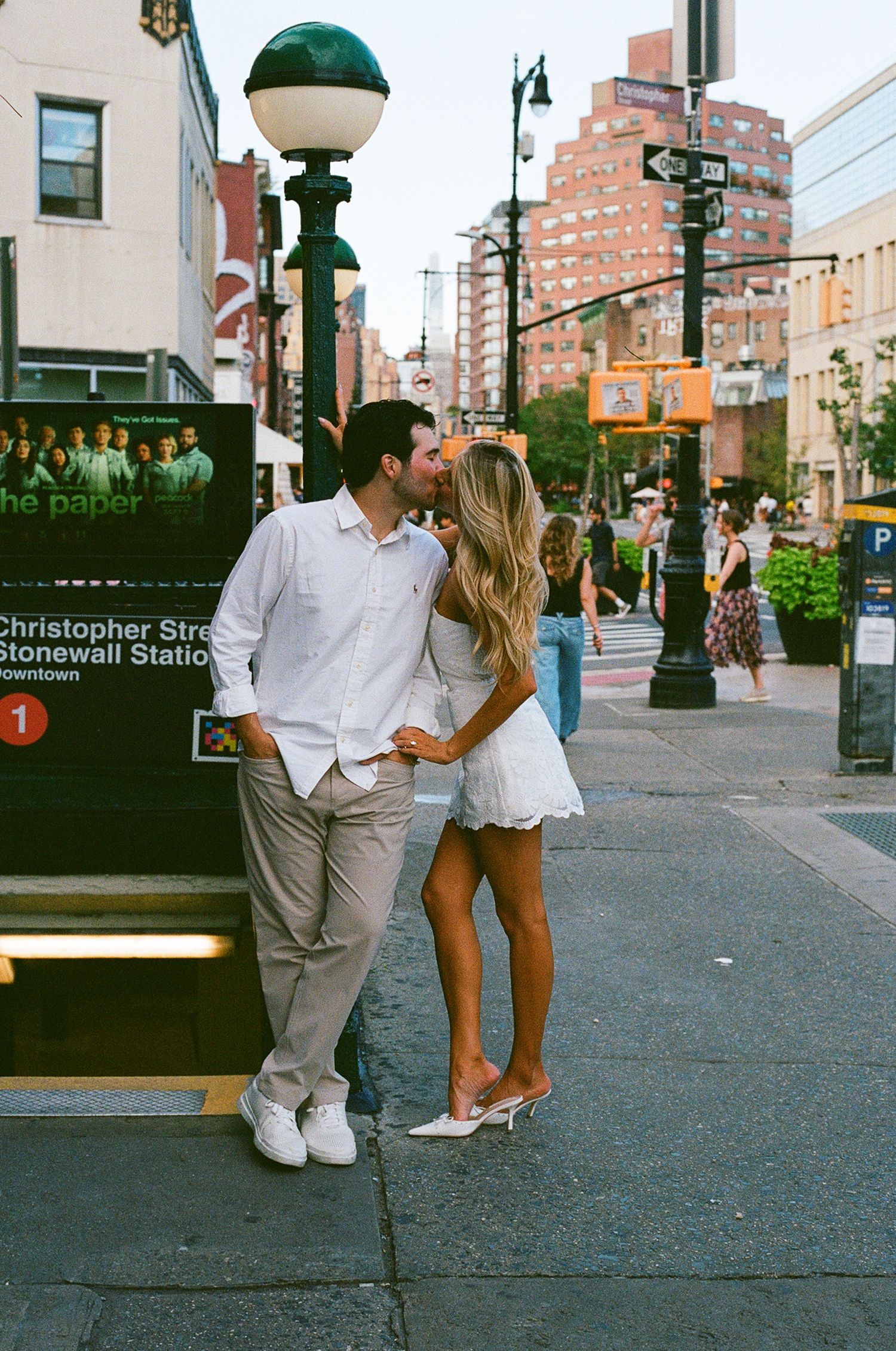 Couple sharing a kiss near Christopher Street Stonewall Station subway entrance in New York City.