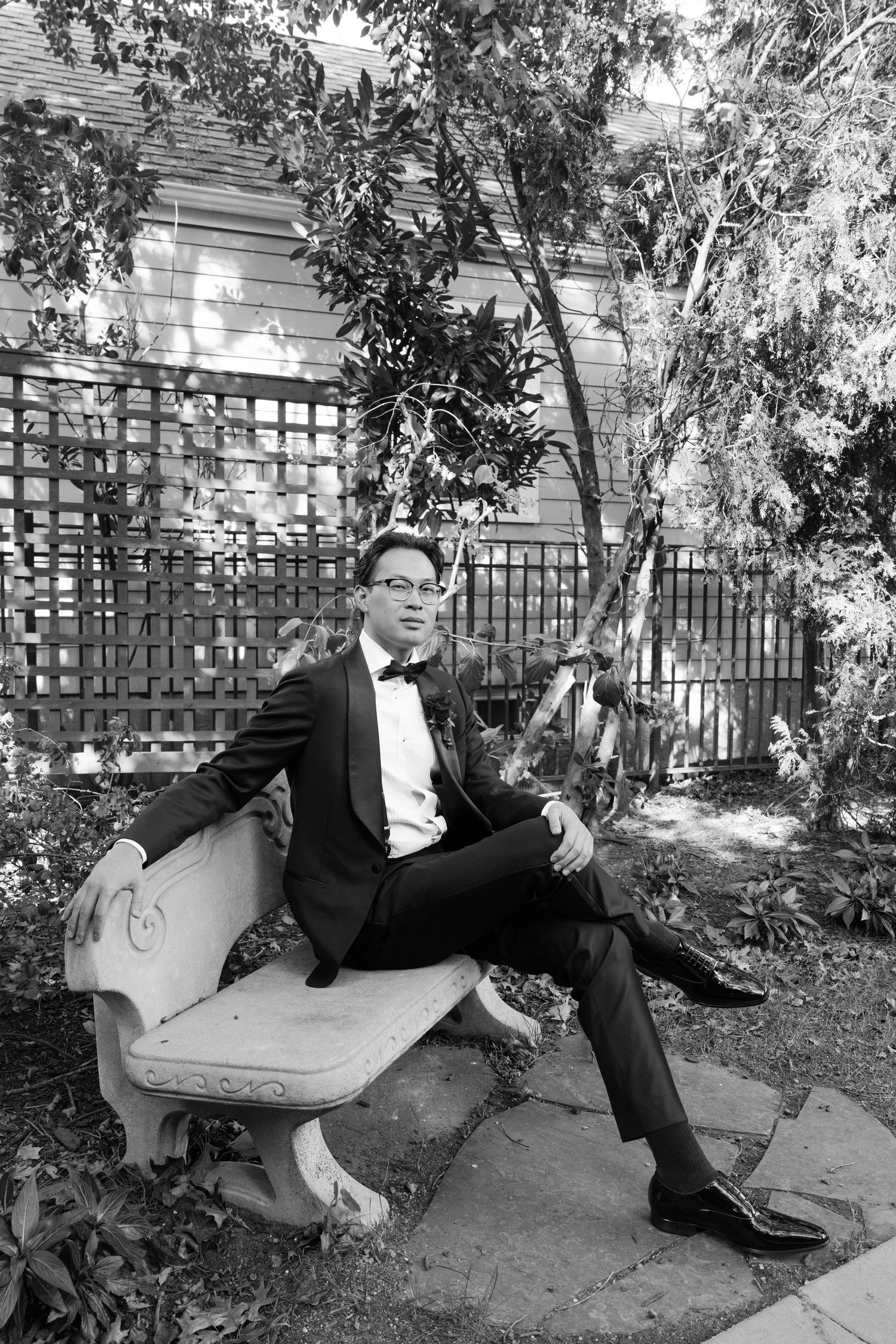 Black and white photo sequence showing a person in formal attire lounging on a curved stone bench in a garden setting.
