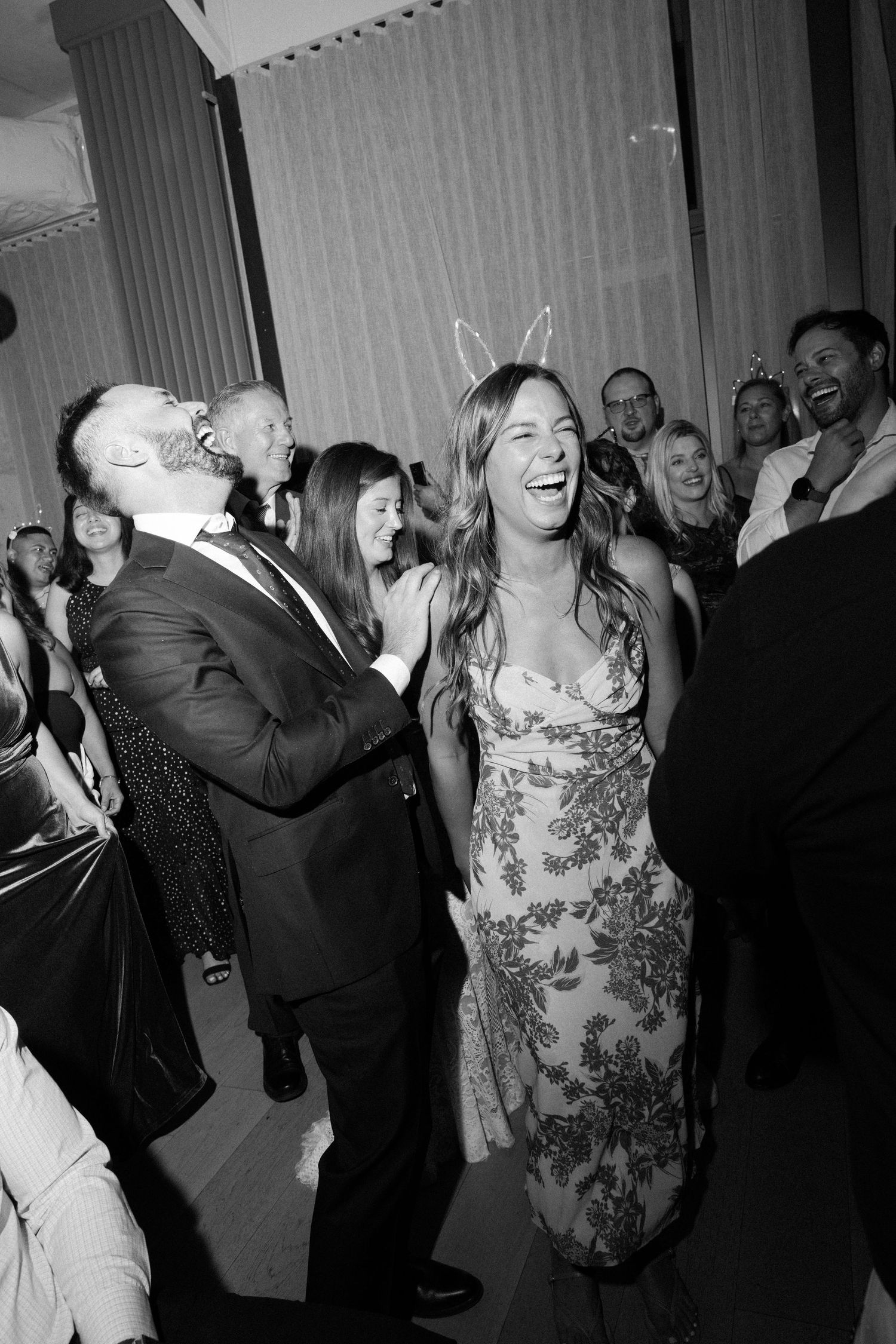 Wedding guests dancing and celebrating on a lively reception dance floor.