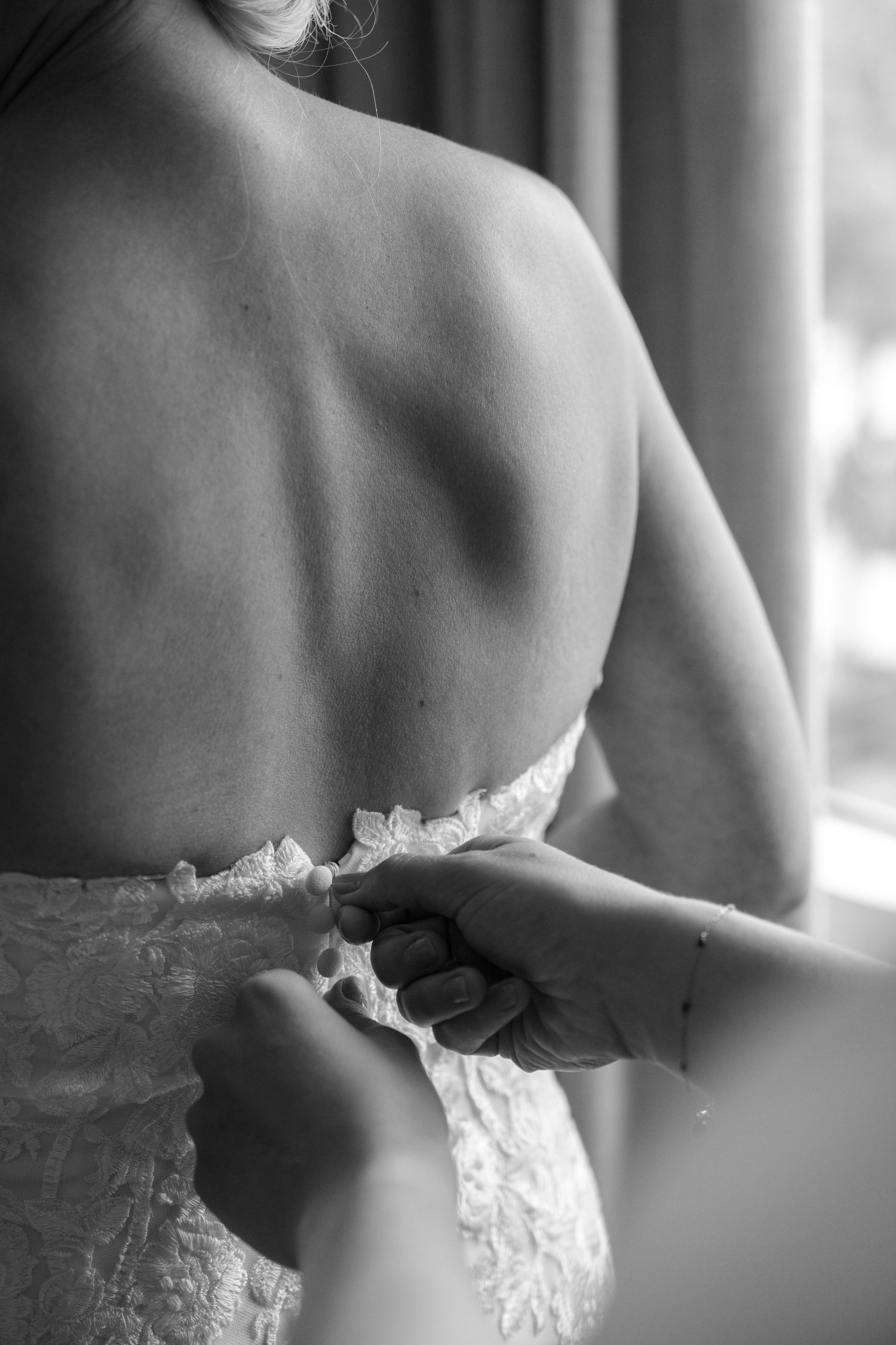 Close-up detail of a white lace wedding dress bodice and back.