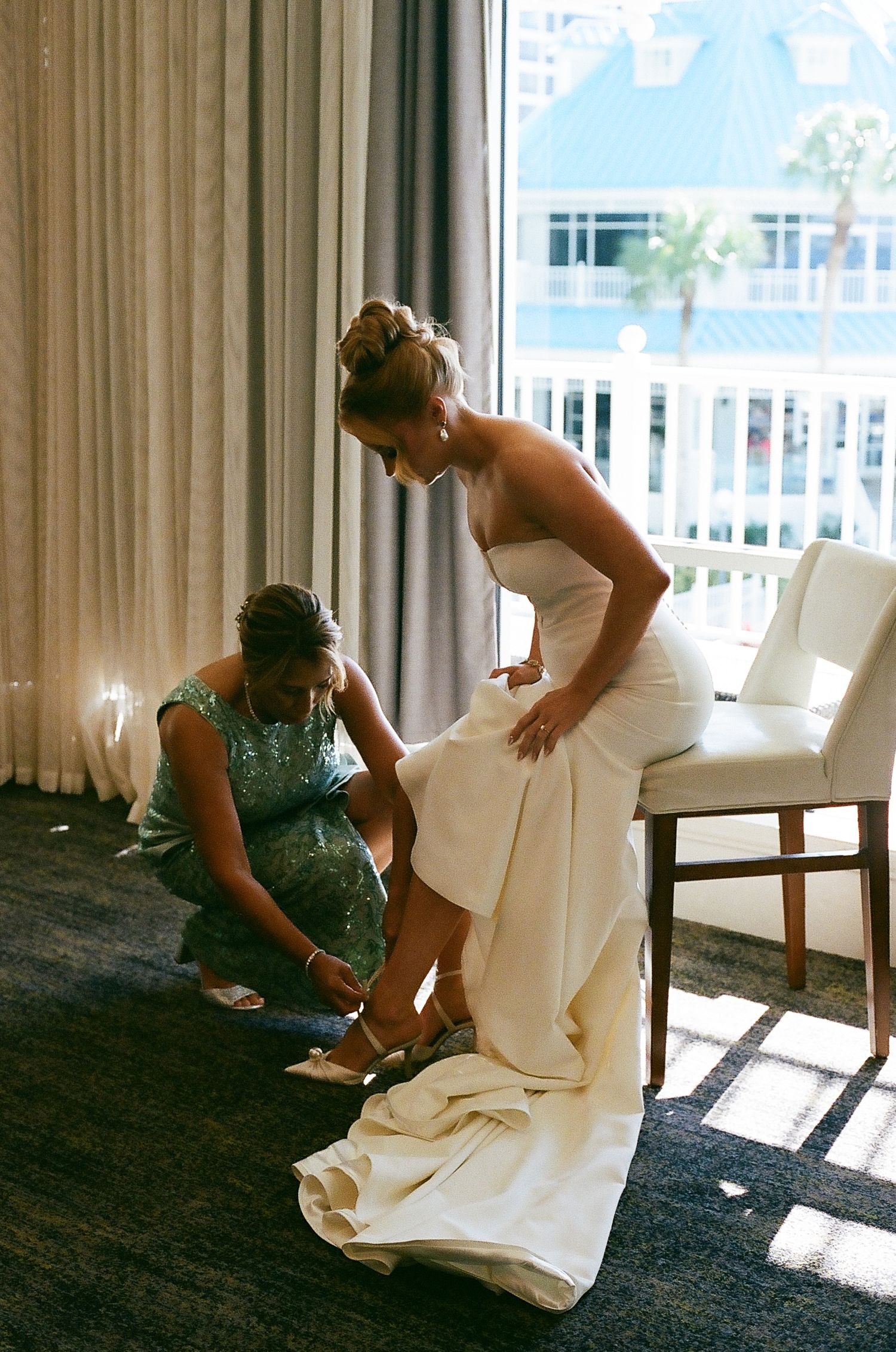 A series of photos showing someone putting on shoes while wearing a white wedding dress in a sunlit room.