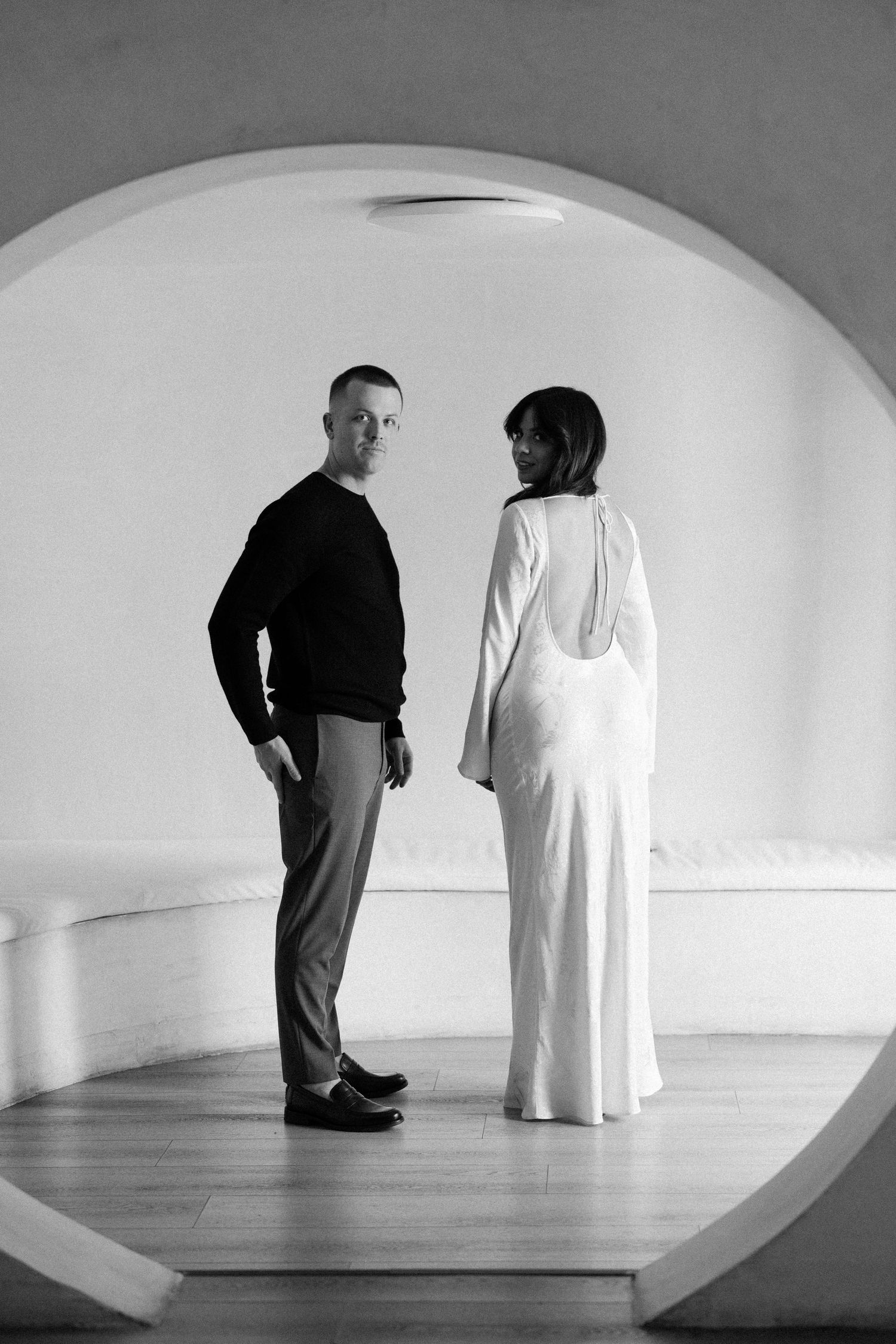 Artistic black and white photo series showing two people in a curved white gallery space.