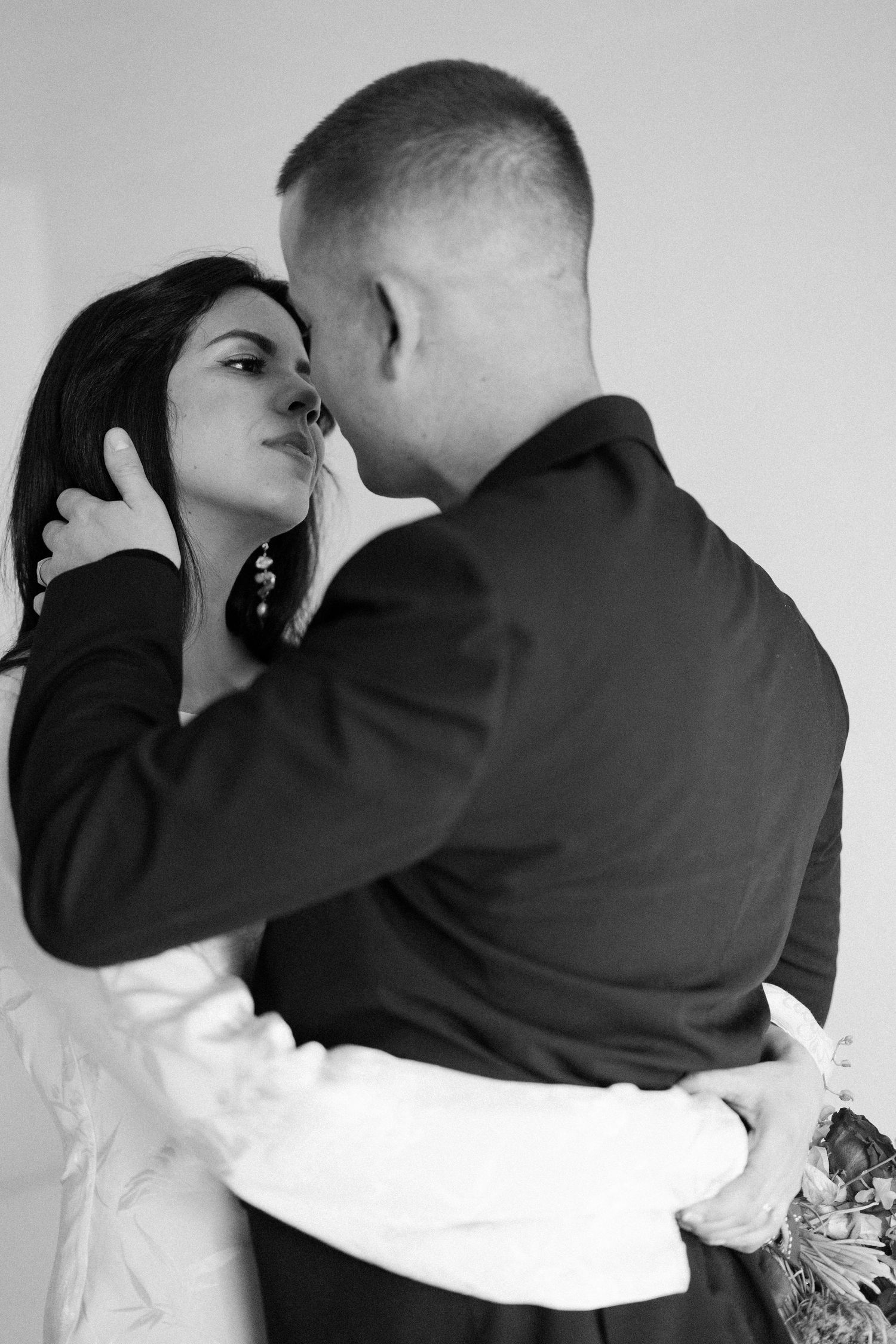 Artistic black and white photo sequence of couple embracing against white background.