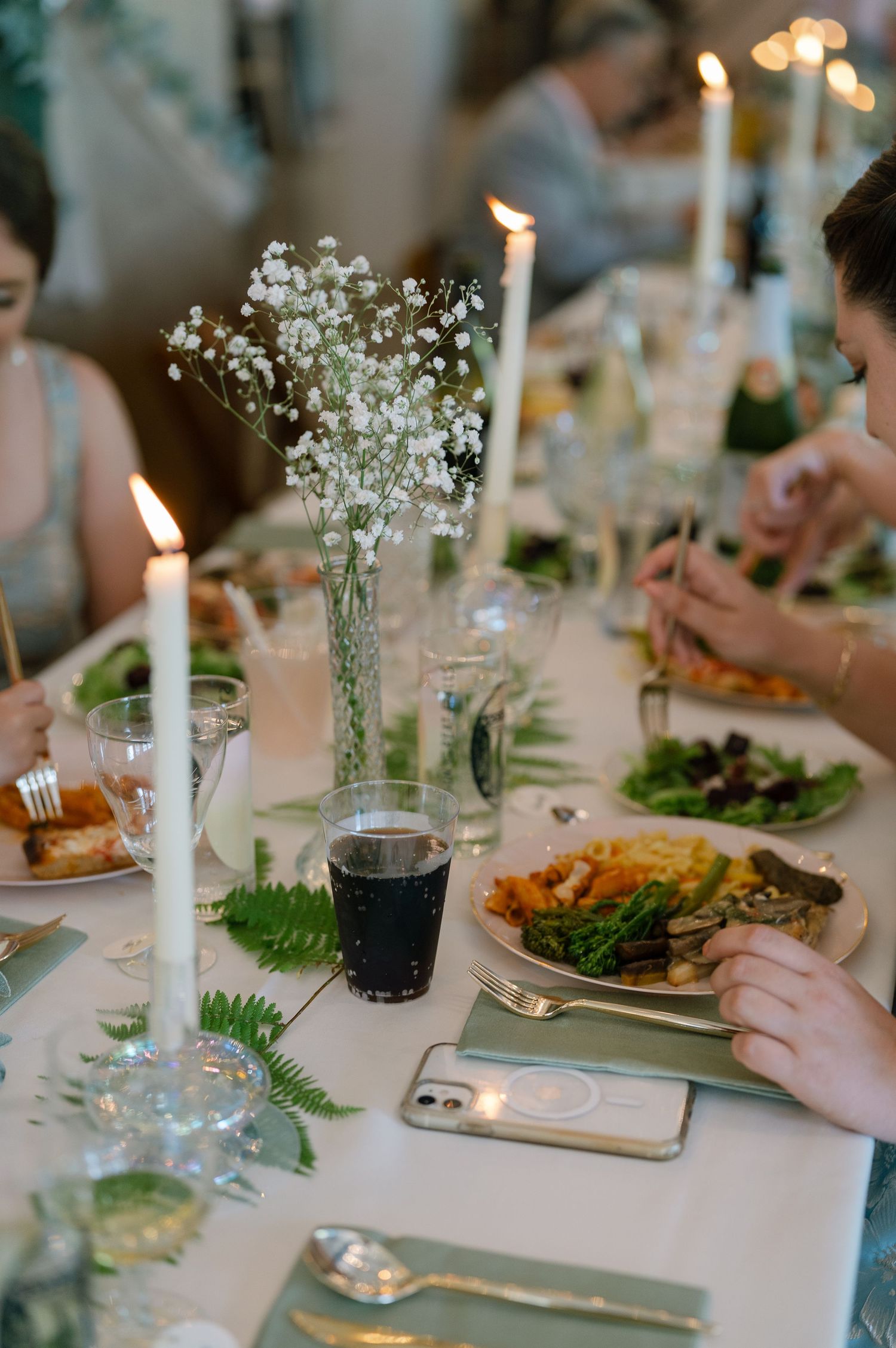 Elegant wedding reception table setting with candles, baby's breath flowers and place settings.