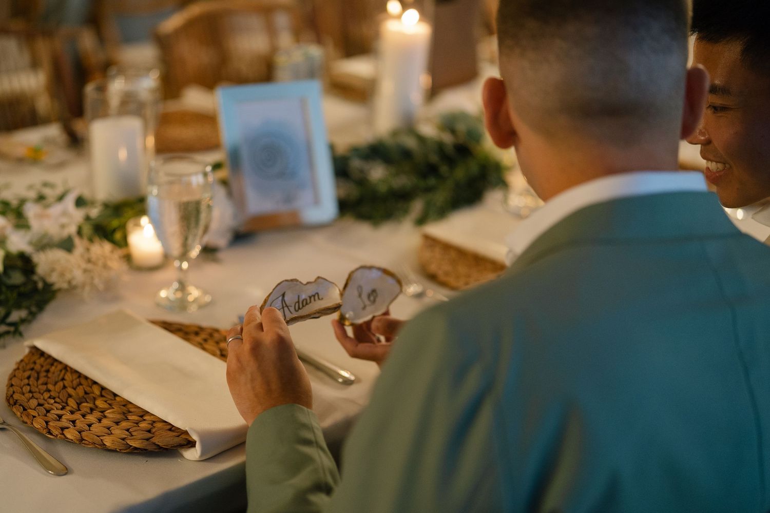 Close-up view of elegant place settings at a formal dinner event with glowing ambient lighting.