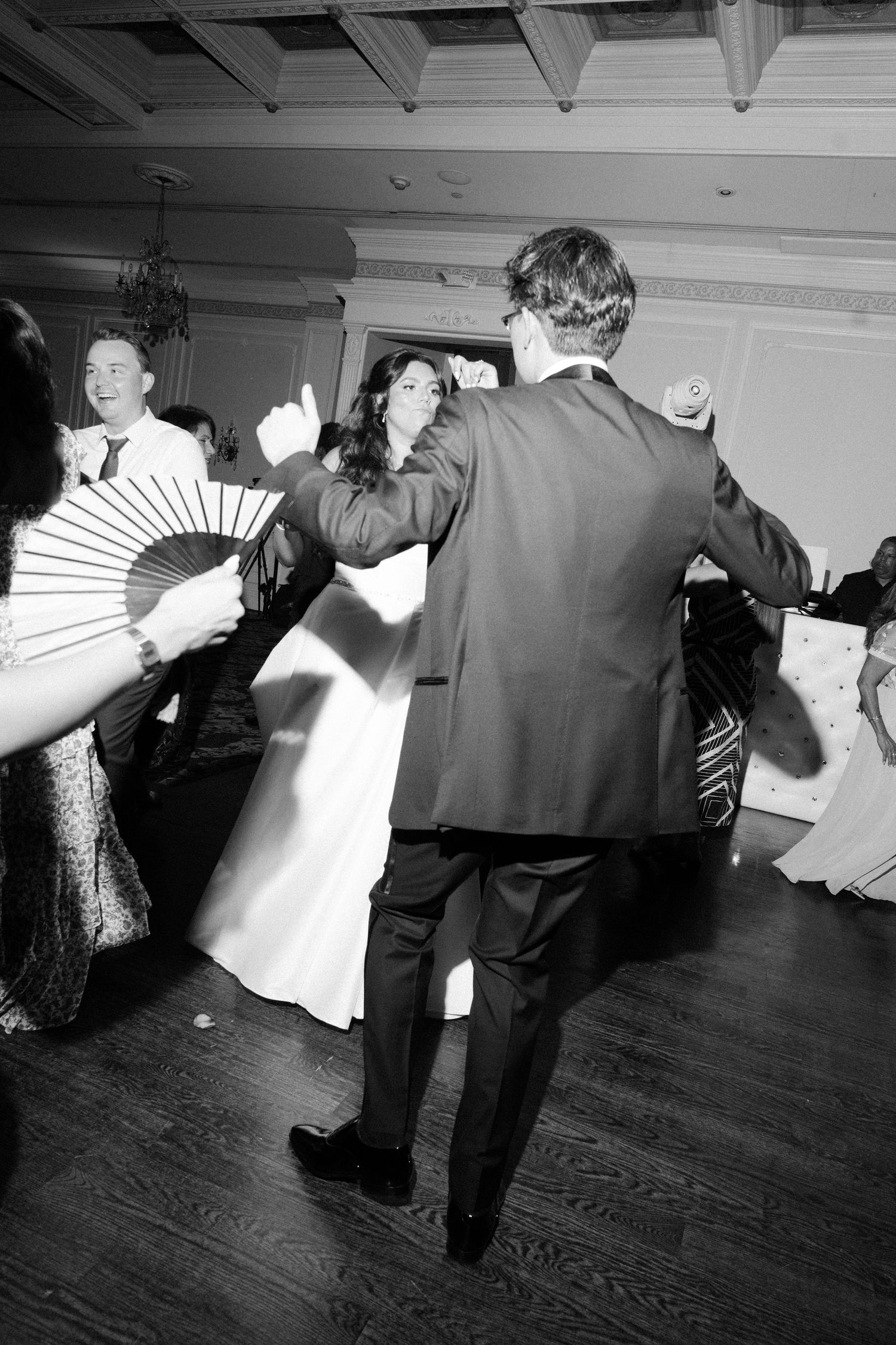 Black and white photos of couples dancing in sequence across a hardwood floor at a formal event.