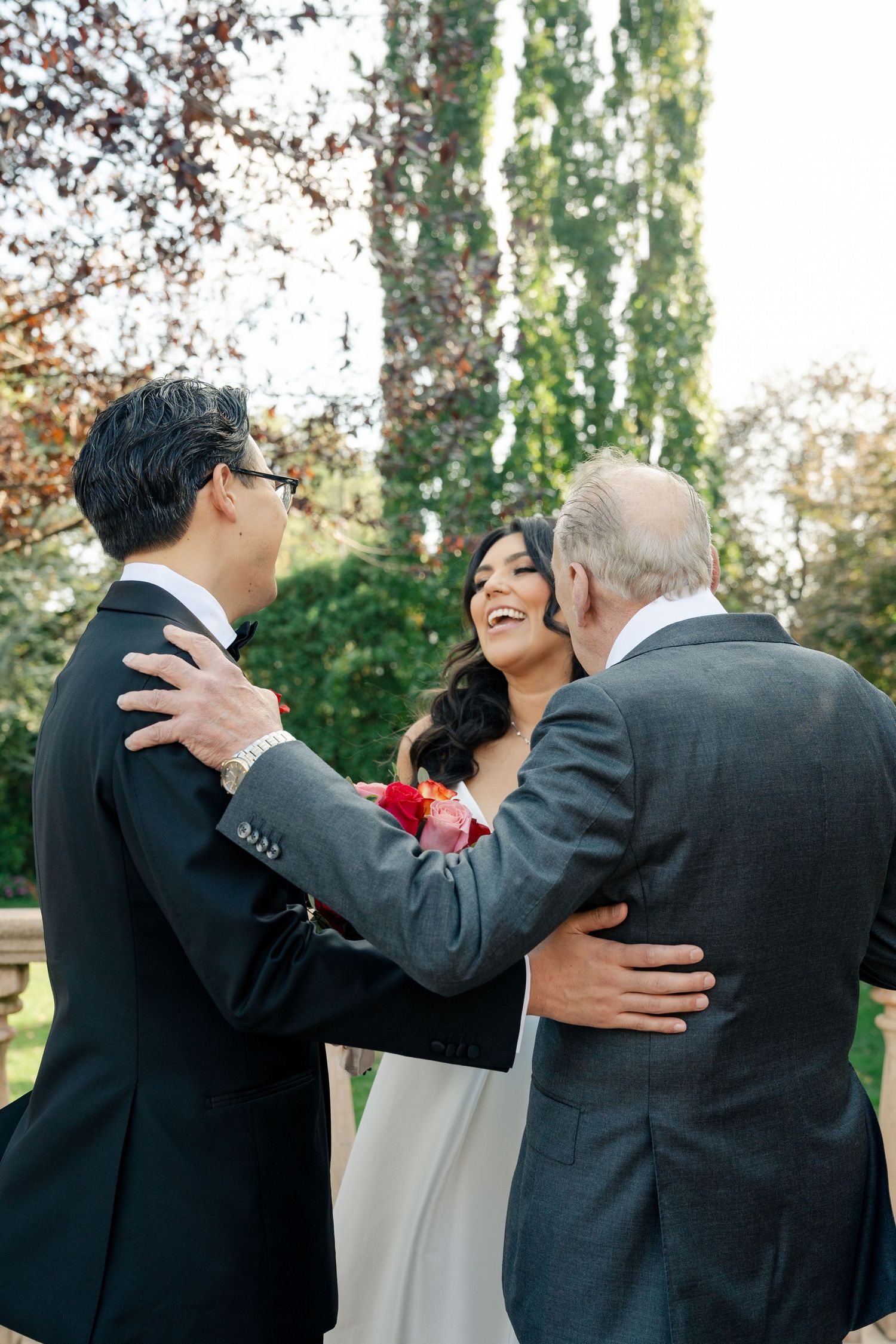 Candid moment of wedding guests sharing laughter outdoors.