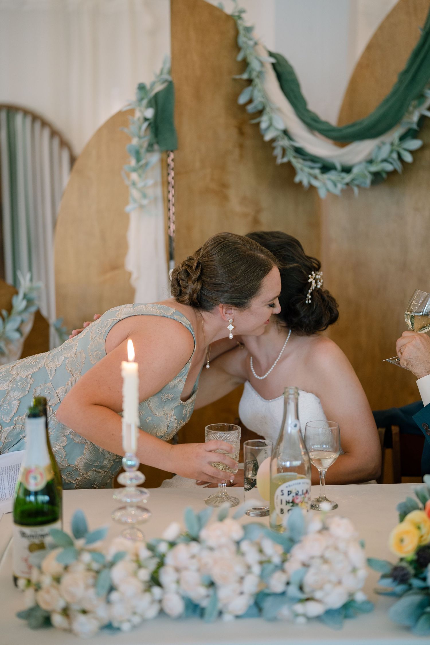 Romantic candlelit table decorated with blue and white floral arrangements at wedding reception.