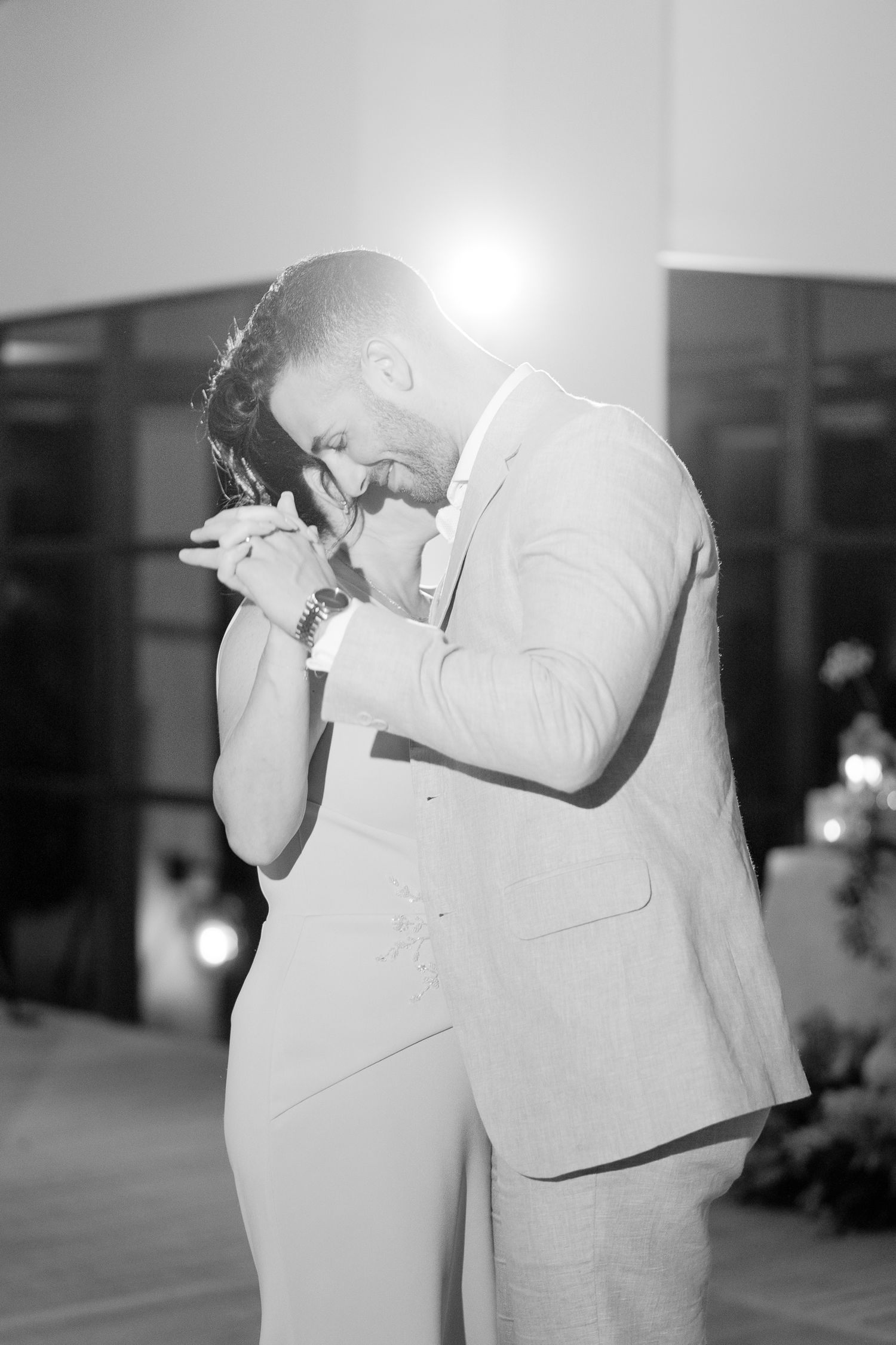 A touching moment at a wedding reception captured in black and white photography.