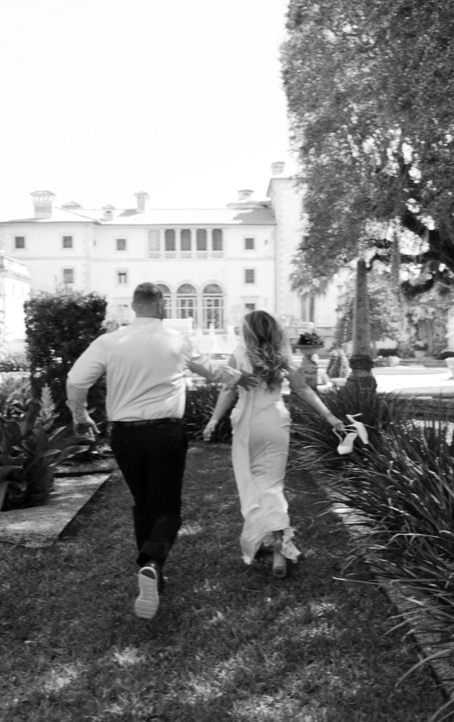 Black and white photo series showing people walking in a garden path beside a large white mansion with landscaped grounds.