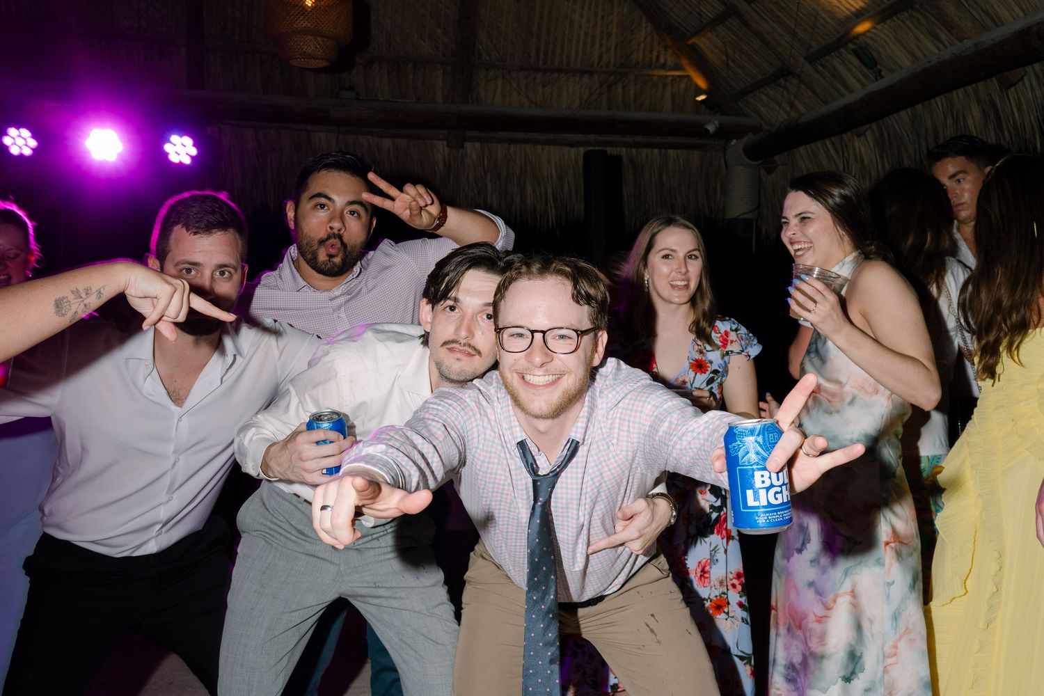 An image of a group of people, likely at a wedding reception, dancing and celebrating together.