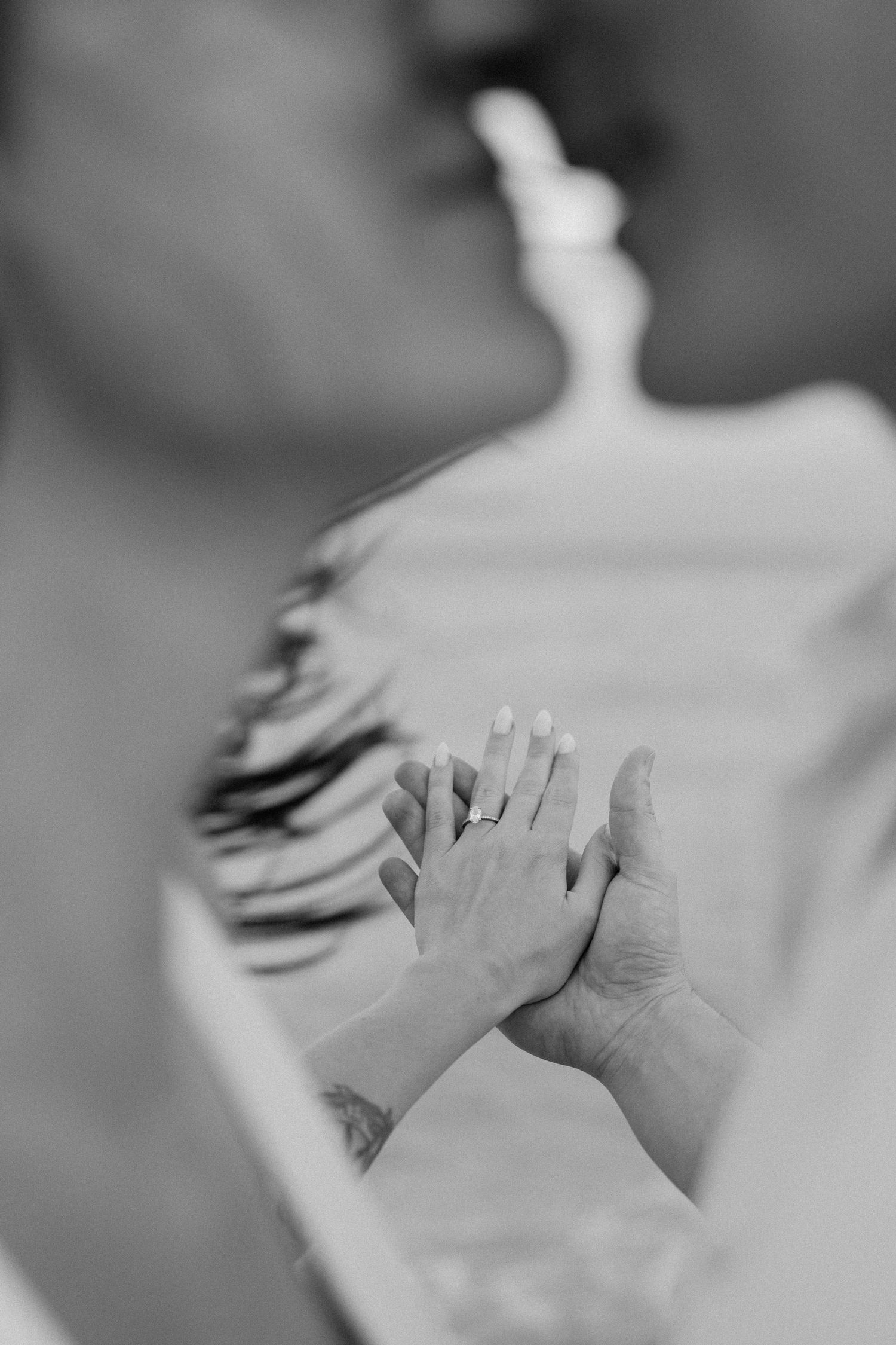 Close-up black and white photo of hands tenderly touching.