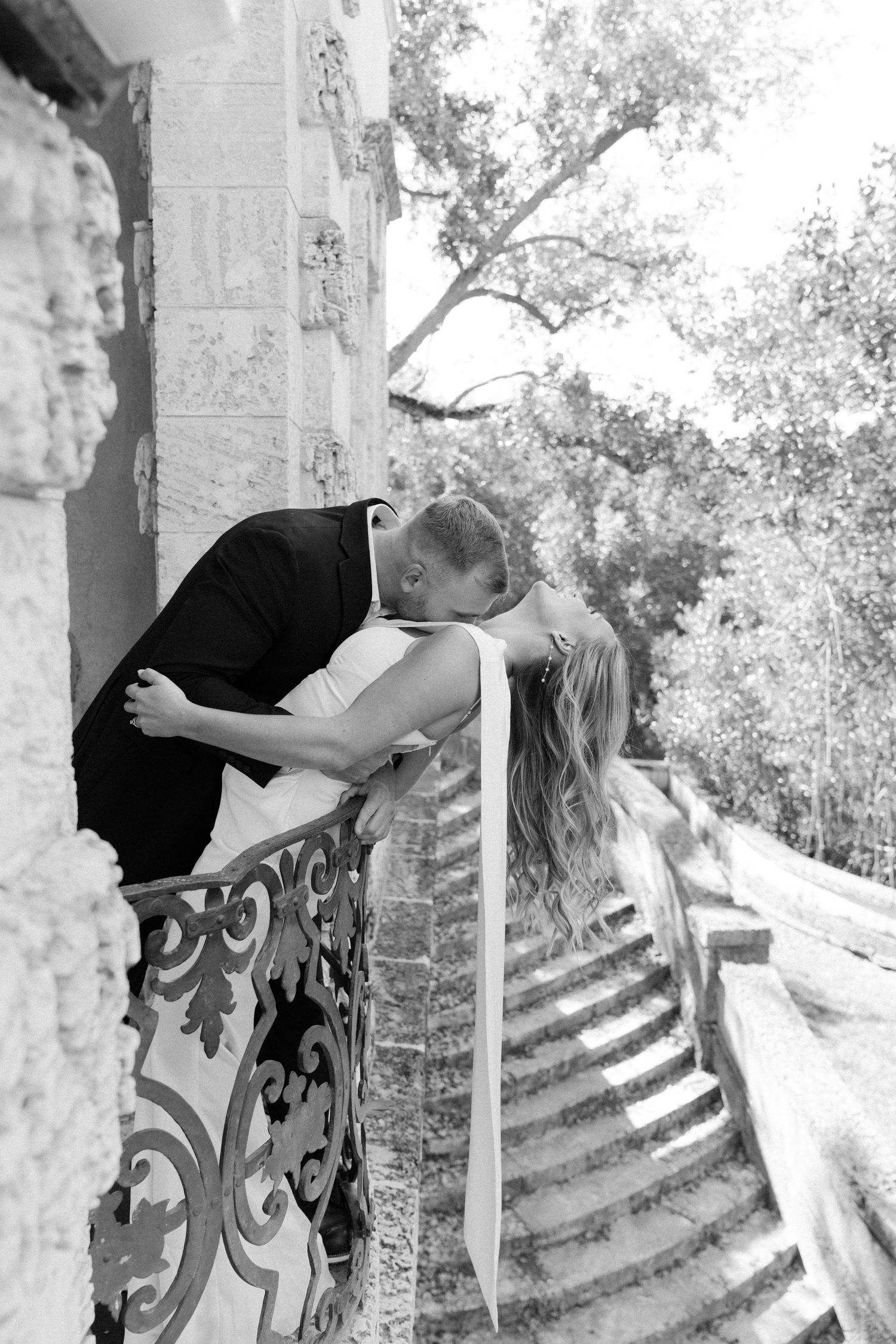 Series of black and white photos showing close ups of couple dancing and embracing near ornate columns and steps.