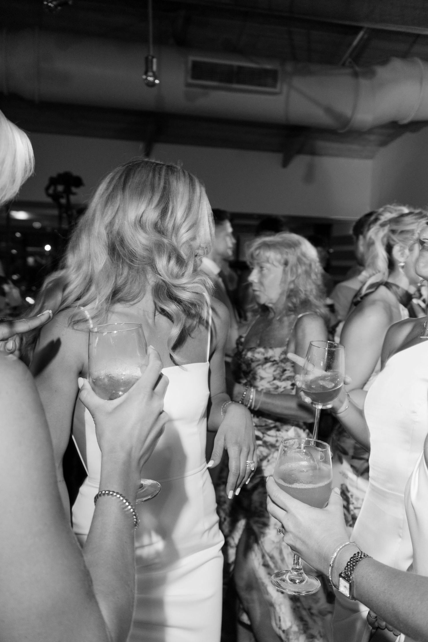 Wedding celebration candid shot showing guests dancing and enjoying themselves at an indoor reception.