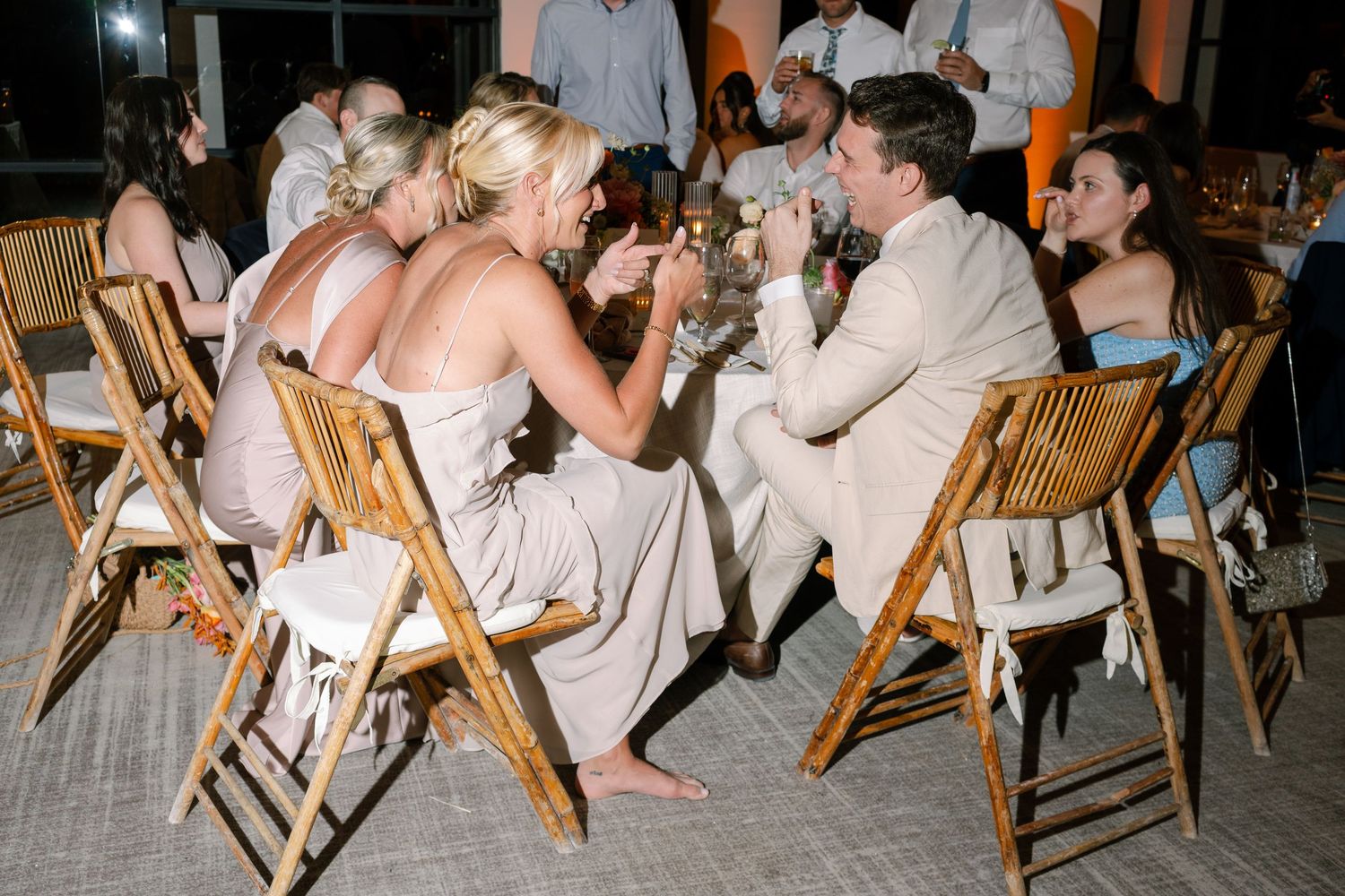 Wedding guests seated in wooden chairs during outdoor reception.