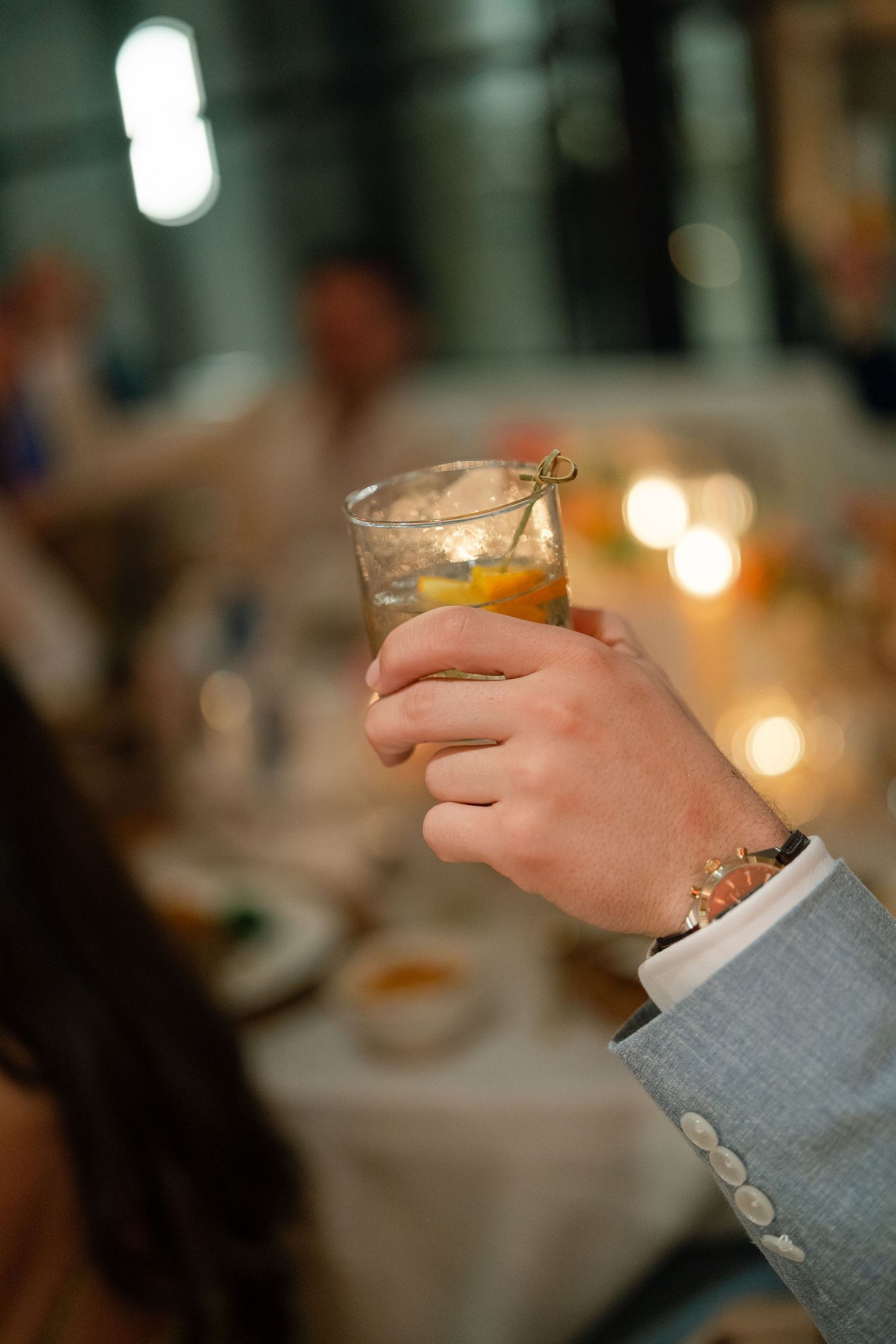 Close-up of hands holding champagne glasses at an elegant wedding reception.