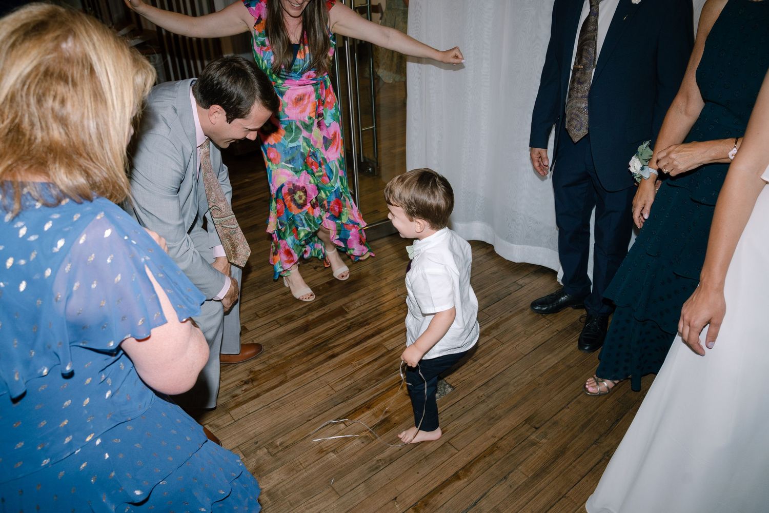 Wedding celebration with colorful confetti flying through the air on a wooden dance floor.