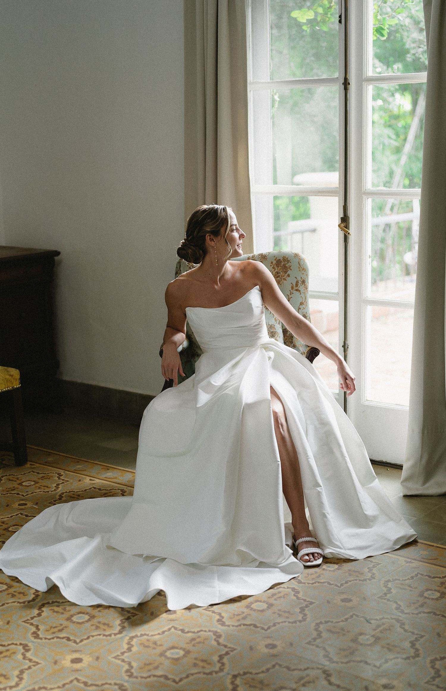 A series of artistic photos showing a person in a flowing white dress sitting on an ornate patterned floor near windows.