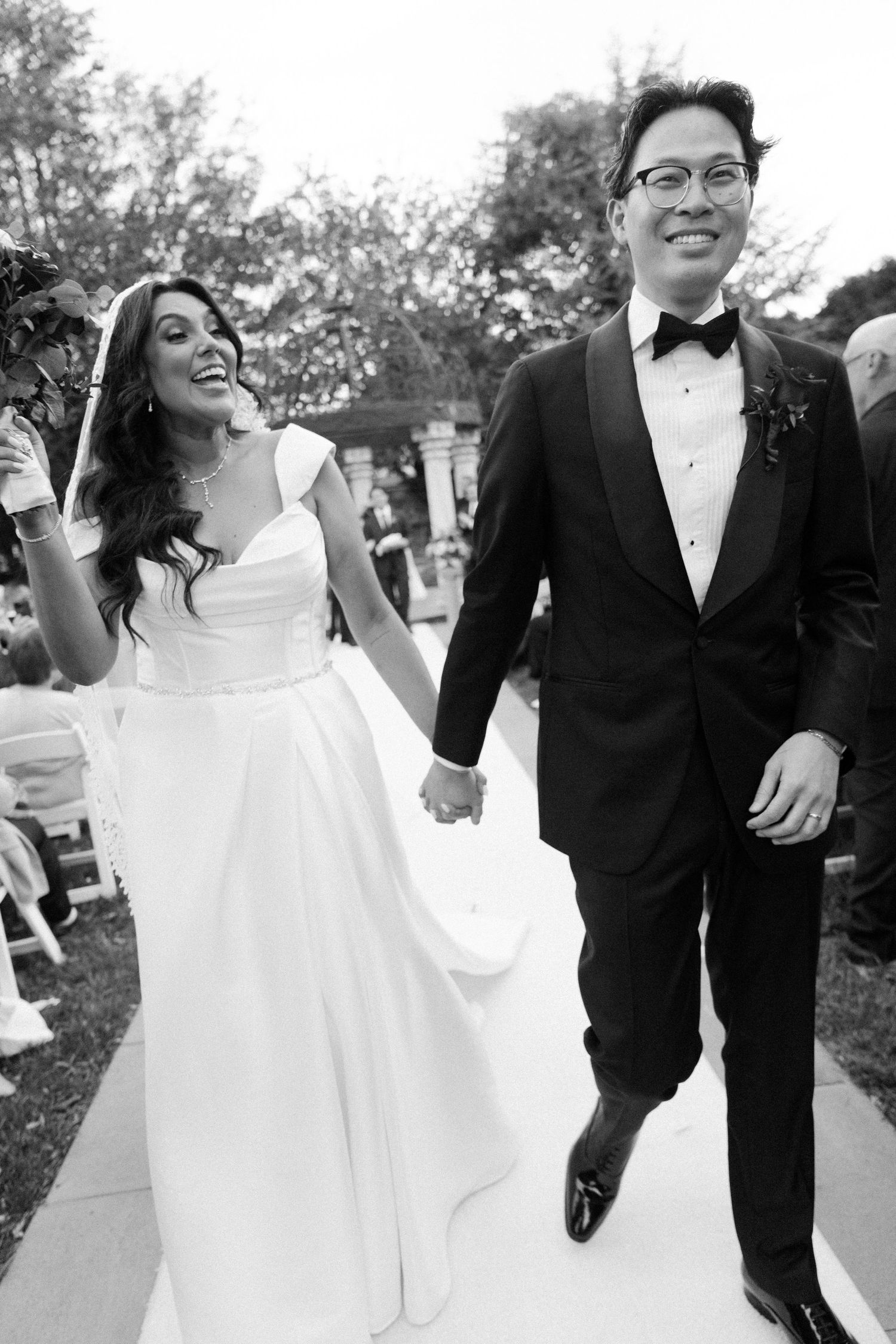 Candid black and white photos of newlyweds walking and laughing together in formal wedding attire.