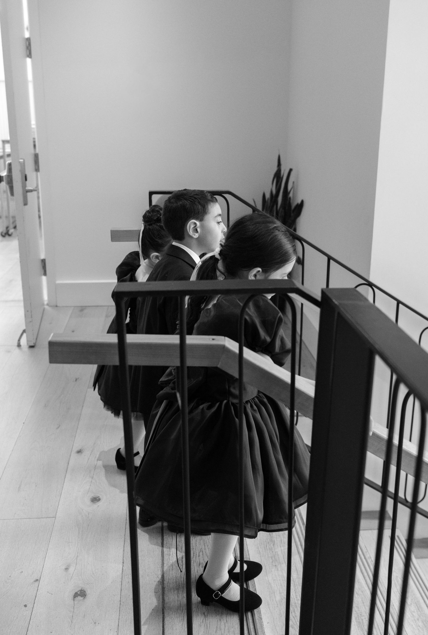 Artistic black and white photo of formal wear hanging on a metal rack.