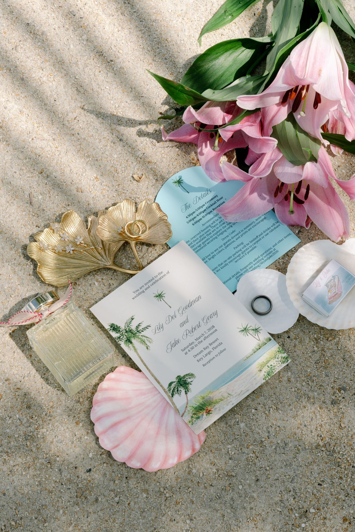 An image showing a variety of items on a sandy surface, including a book, seashells, and a bouquet of pink flowers.