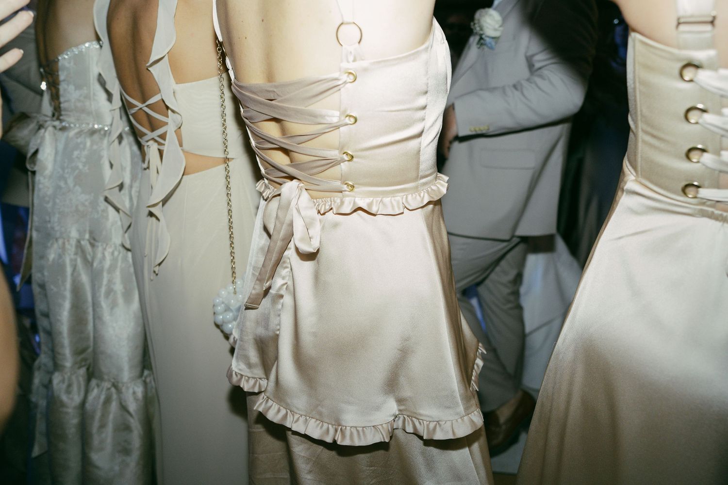 Close-up details of ivory wedding dress corsets and lace-up backs lined up in a row.