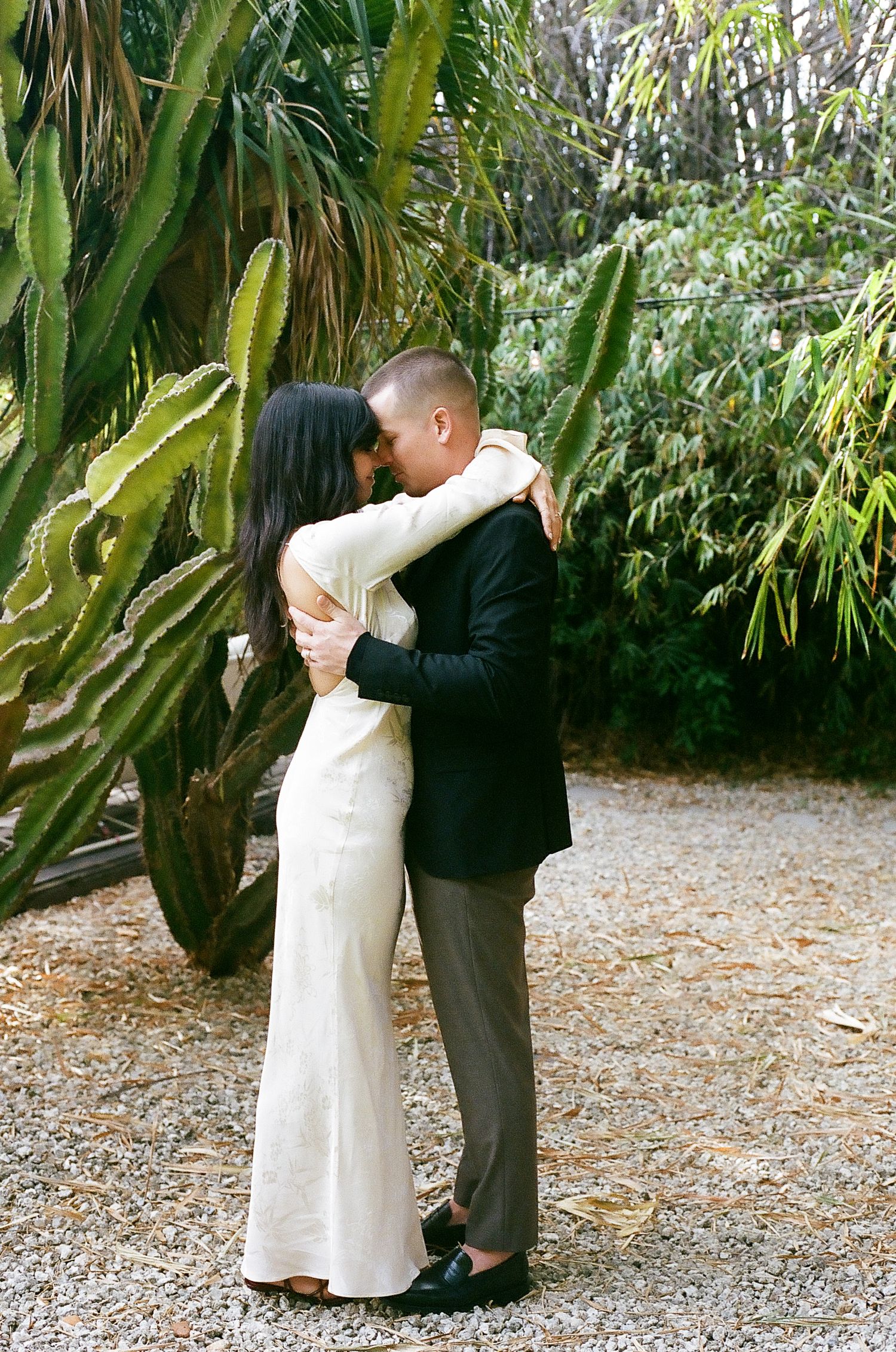 A romantic first dance sequence between newlyweds in a garden surrounded by tropical plants.