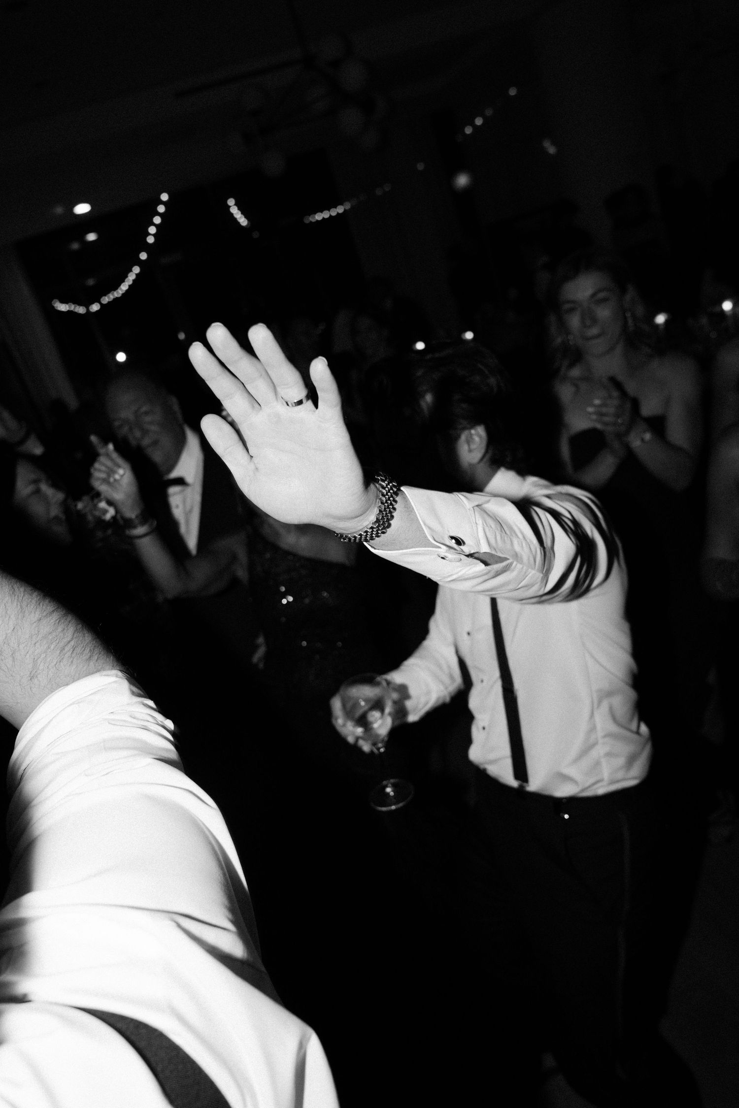 A hand raised in celebration on a dark dance floor during a festive party celebration.