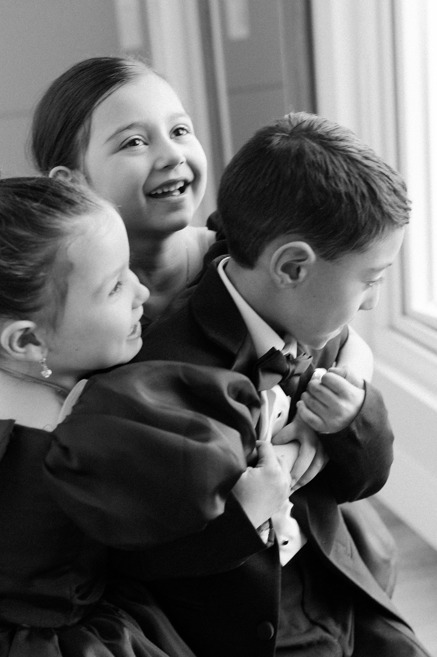 Black and white portrait sequence of young children in formal attire by a window.