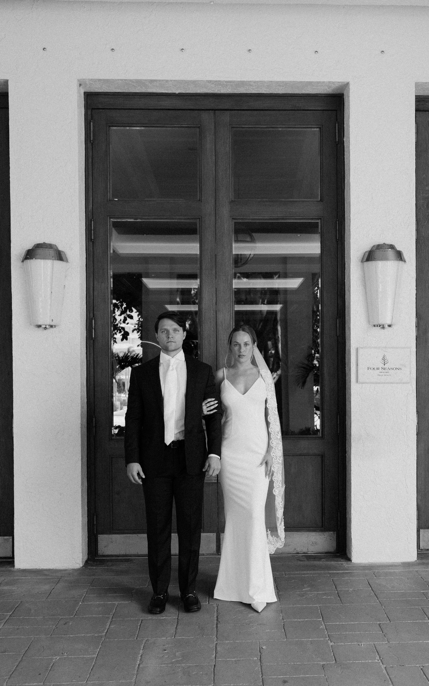 A playful black and white sequence of a couple peeking out from behind two separate doors at a wedding venue.