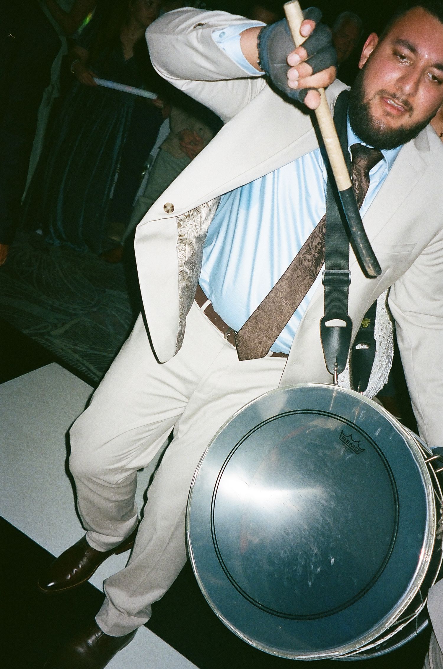 A series of photos showing someone in white clothing flipping and spinning a dark frying pan in a dimly lit setting.