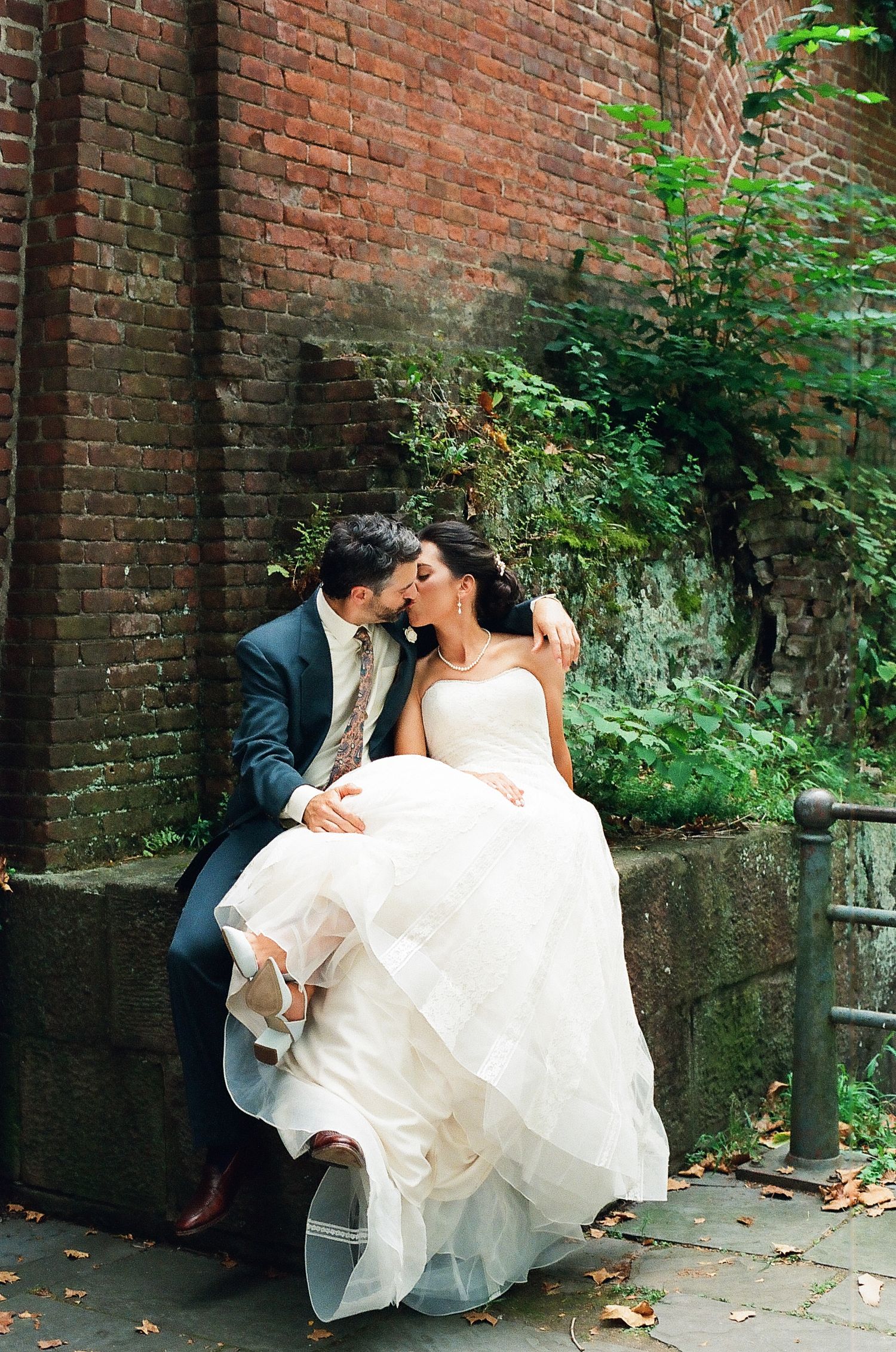 A romantic series of wedding photos showing a couple sharing intimate moments against a rustic brick wall backdrop.
